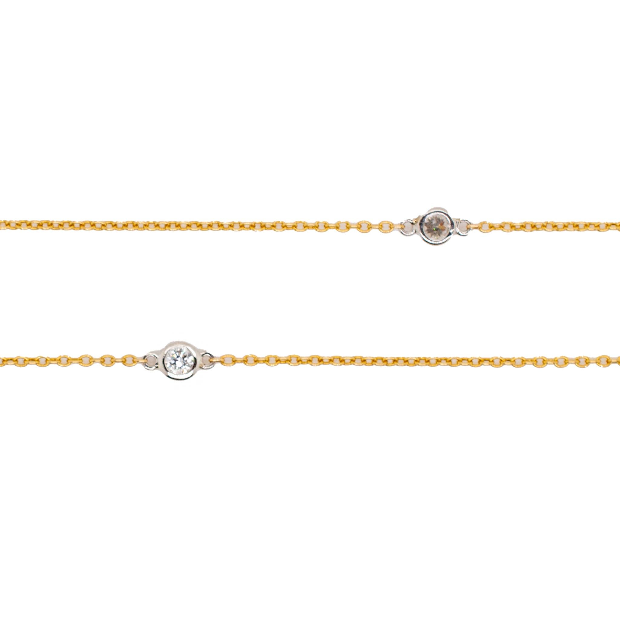 One lady's designer made polished, filigree-style, platinum and 18K yellow gold single strand opera, diamond station necklace. The necklace measures approximately 40.00 inches in length by 3.20mm tapering to 1.30mm in width and weighs a total of