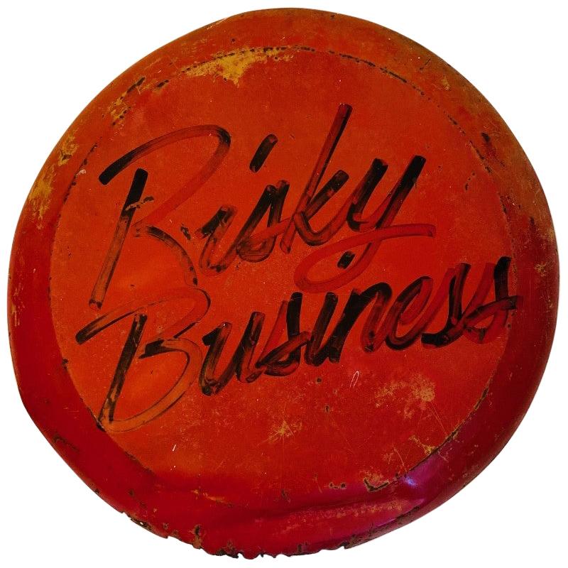 Fun and original piece of memorabilia to the film “Risky Business”. This piece is a sign that references the title of the movie with the same calligraphy applied to the movie advertisements. 28” in circumference and in vintage condition. A fun and