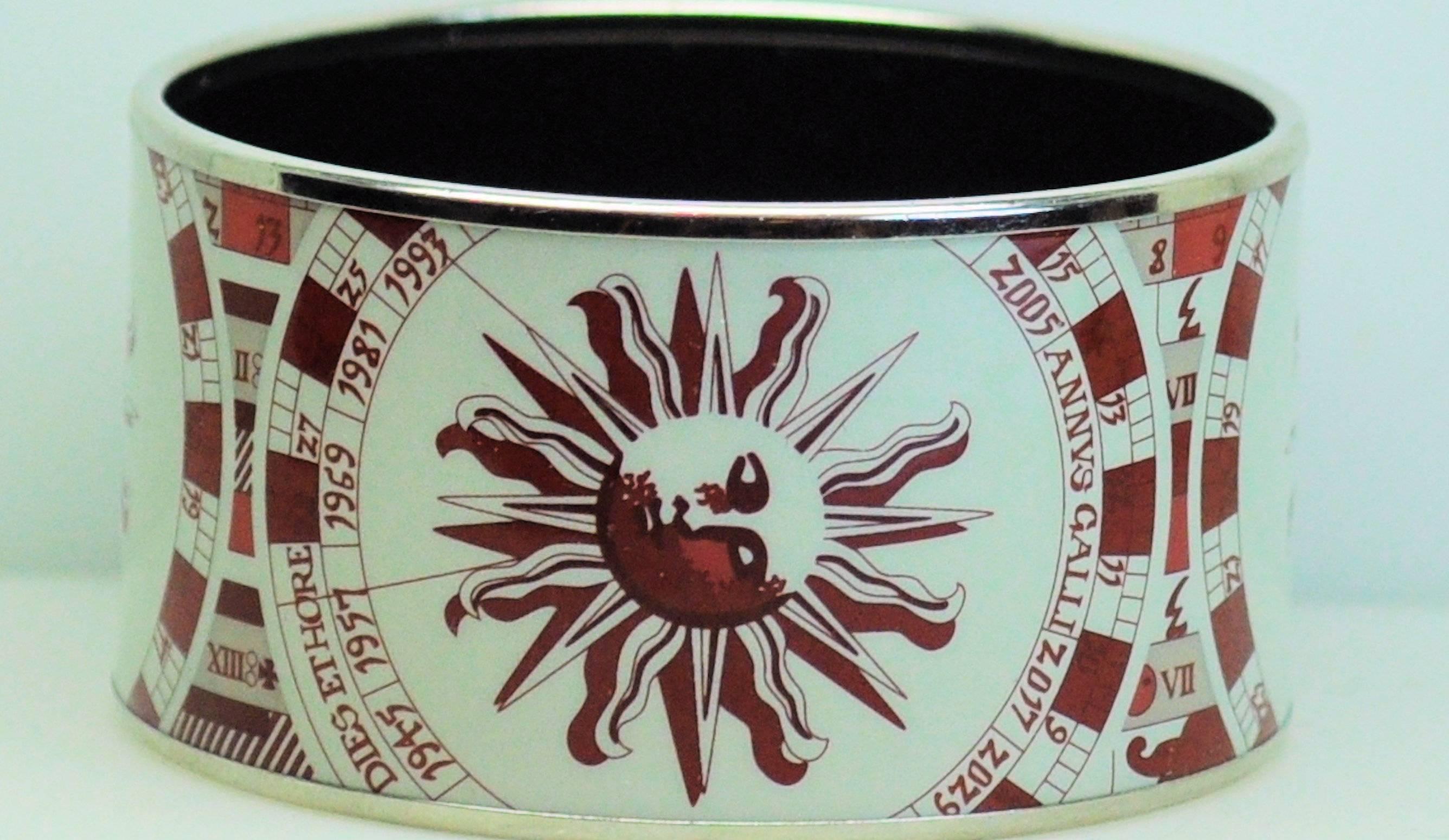 Vintage Hermes wide bangle bracelet in shades of red on white background, sunface and zodiac symbols. 
Made in Austria, signed Hermes Paris. Date letter +M