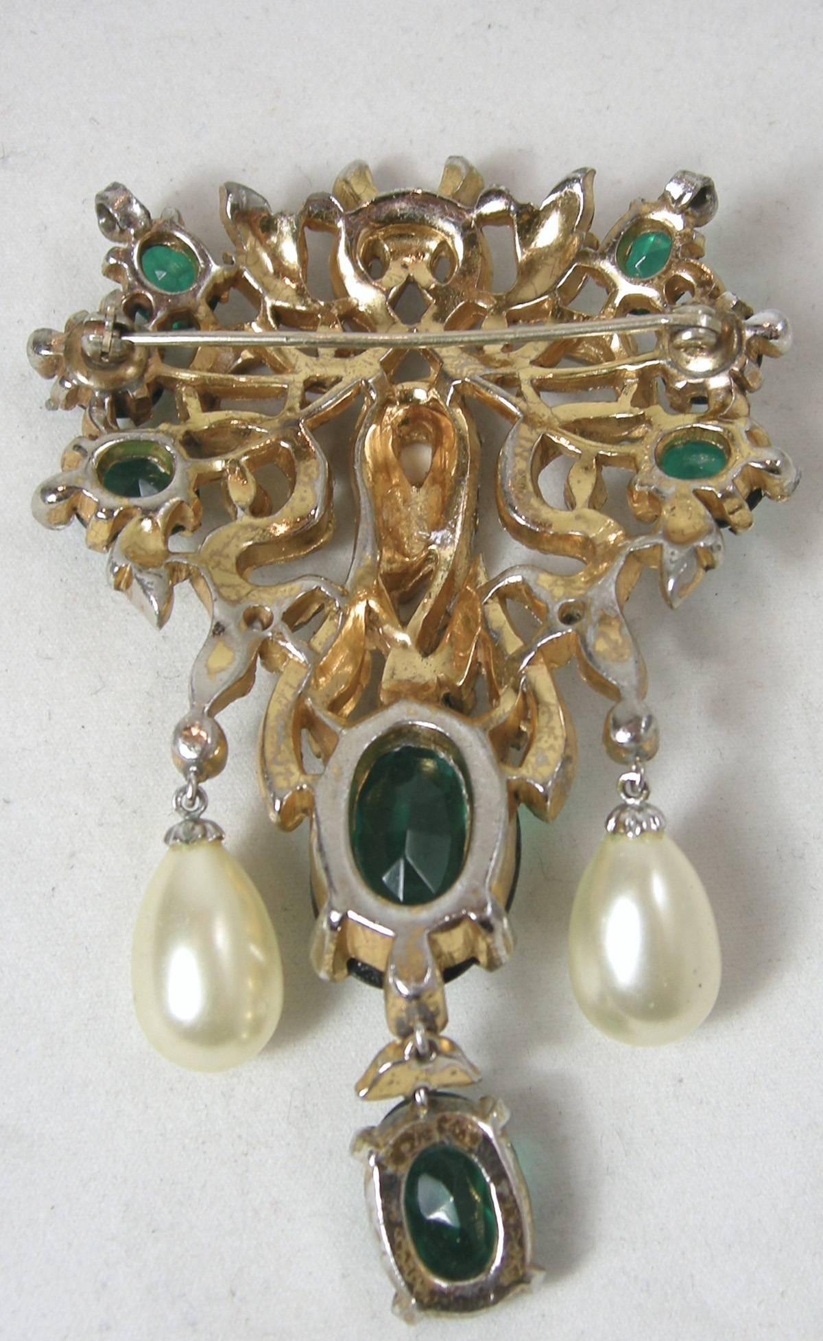 Although this magnificent brooch is not signed, it is without a doubt an important piece from Trifari’s famous Empress Eugenie collection.  The brooch has a gold vermeil with emerald green crystals with pave crystals and black enameling intertwining