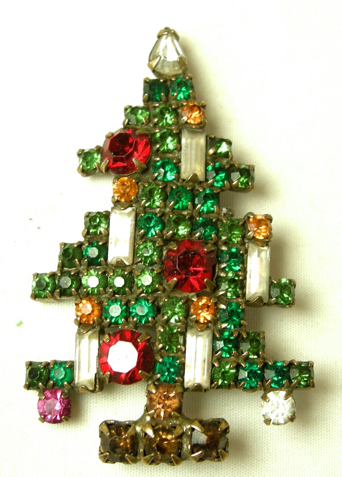 It is rare to find the Weiss 5 candle Christmas tree pin with matching earrings … but here it is. It is filled with multi-color crystals in a gold tone setting.  The brooch measures 2” x 1-1/2” and the matching clip earrings are 1-1/4” x ¾”.  Both