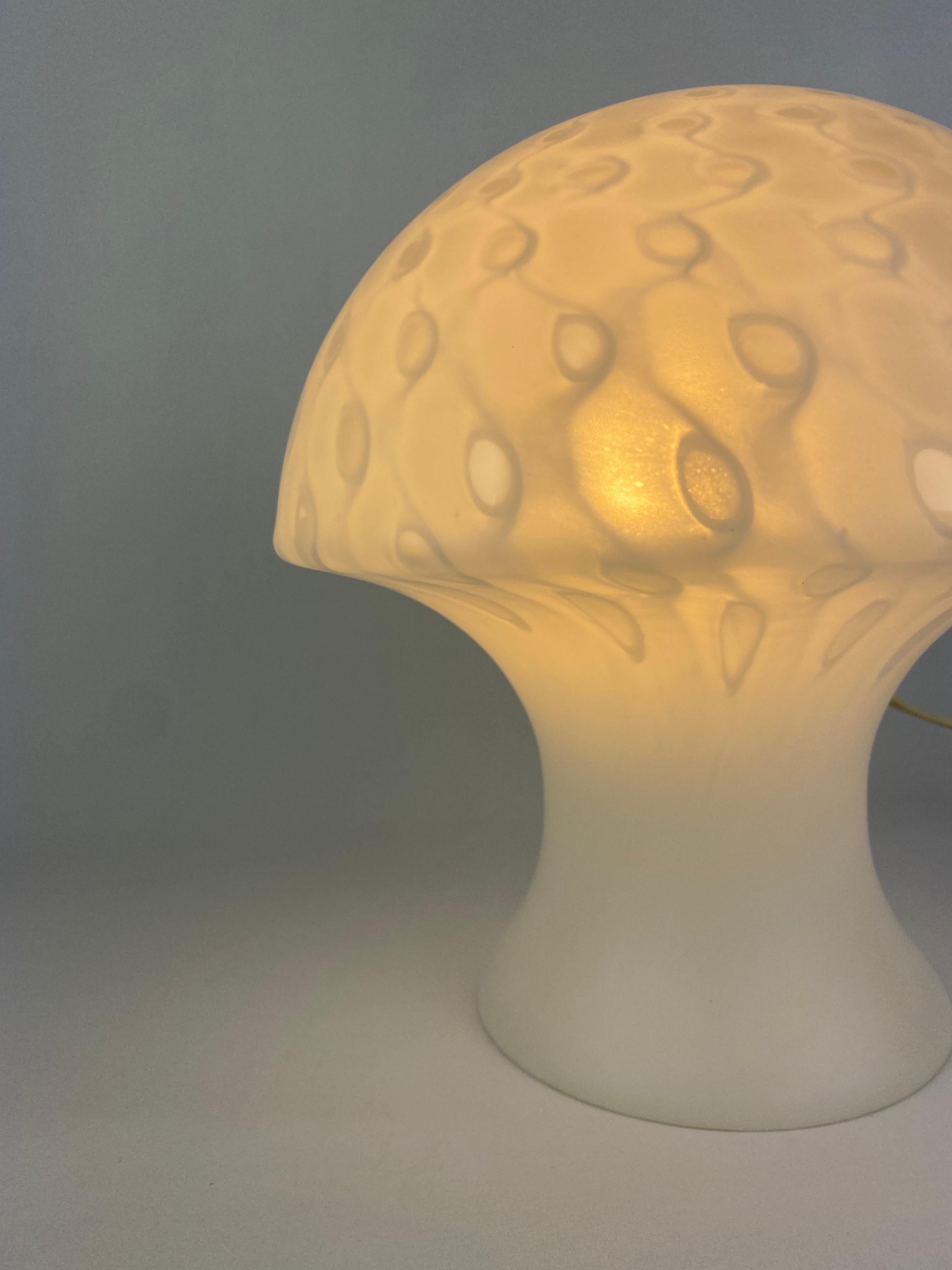 Very cool glass mushroom lamp by Peill and Putzler, produced around 1970 - 1980. This model is not very common.

This lamp is made of one mouth-blown piece of crystal glass with a interesting print and it's shaped like a typical mid-century