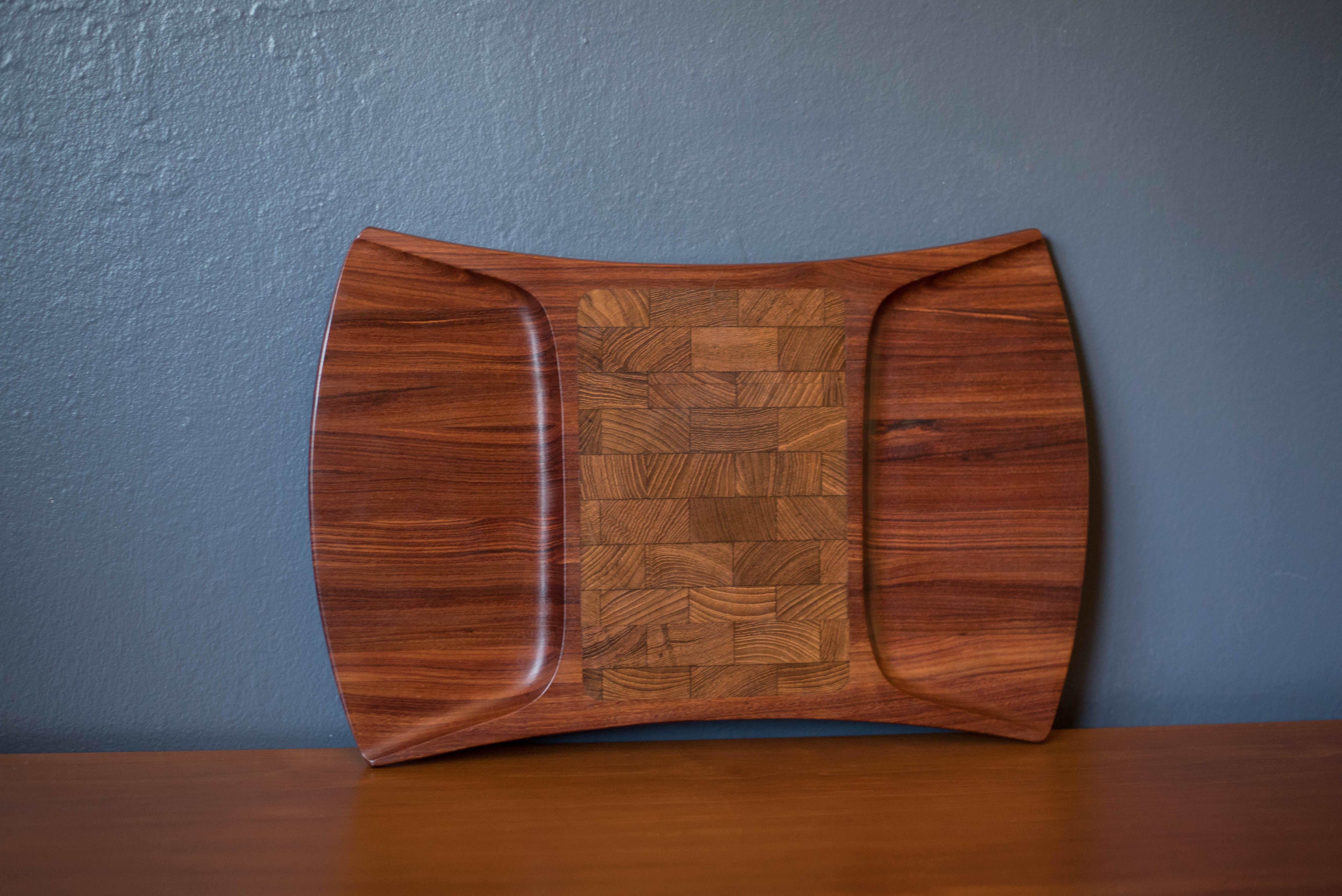 Mid-Century Modern charcuterie cutting board designed by Jens H. Quistgaard for Dansk, Denmark. This stunning piece is part of the rare woods collection and is crafted in pao rosa, a tropical African hardwood. Perfect for entertaining and serving