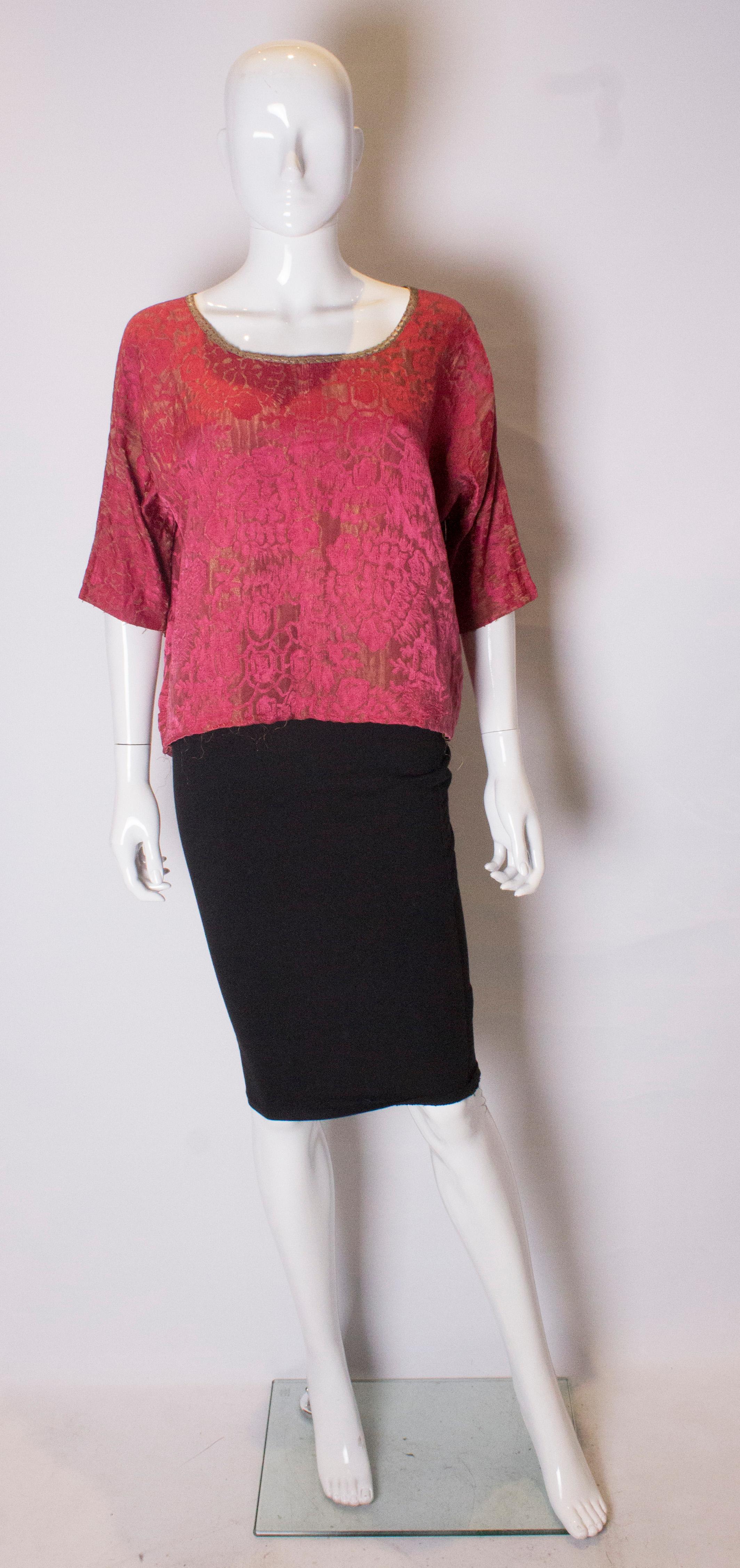 A wonderful  t shirt shape top , made of vintage fabric. 
The top is in a pretty raspberry colour with gold lame detail, and gold trim at the neckline.