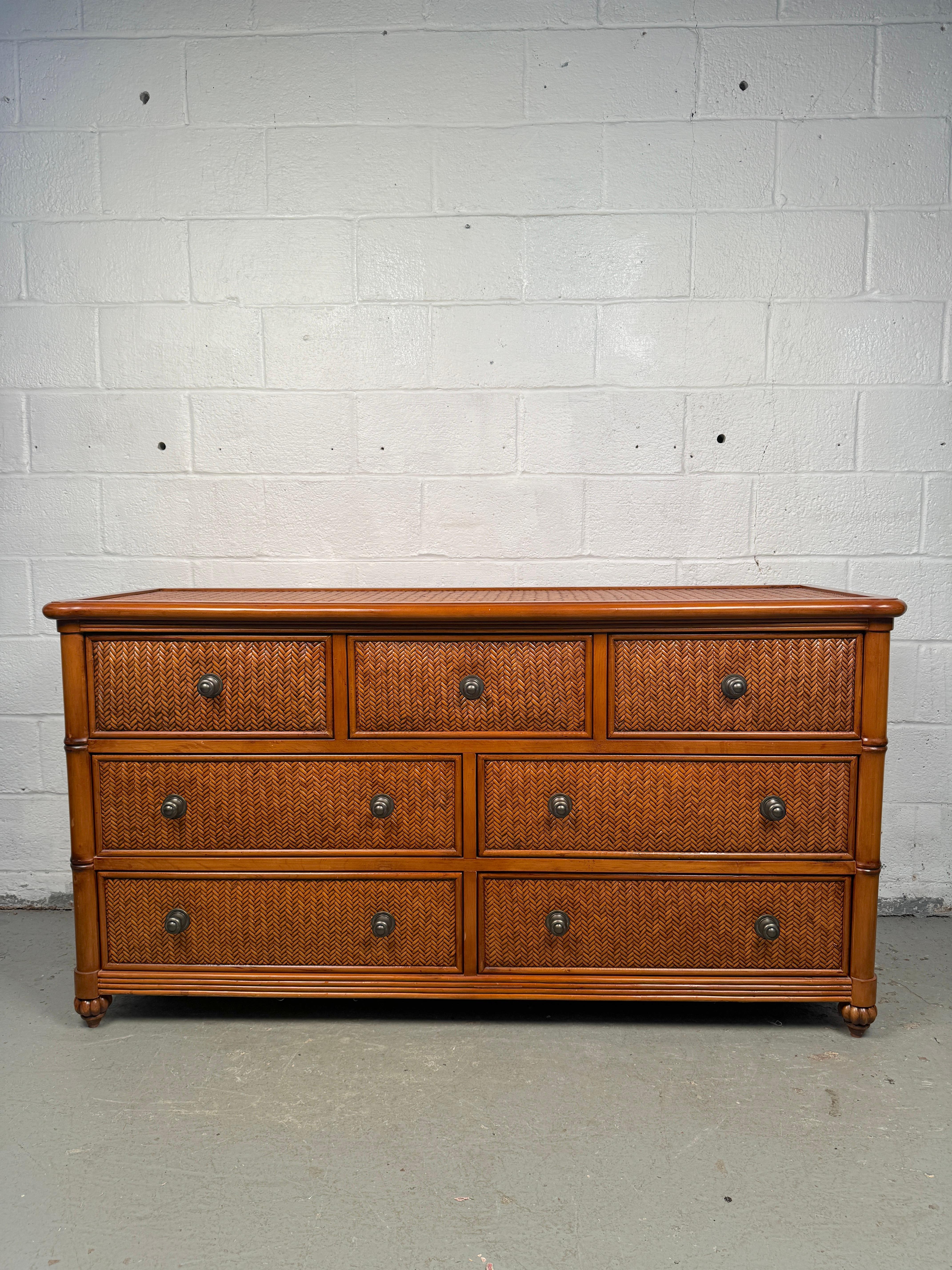 Questo comò a sette cassetti in rattan e bambù vintage è una fusione perfetta di eleganza tropicale e funzionalità. Realizzato con un robusto telaio in legno avvolto in rattan intrecciato e accenti di bambù, questo comò offre sia spazio per riporre