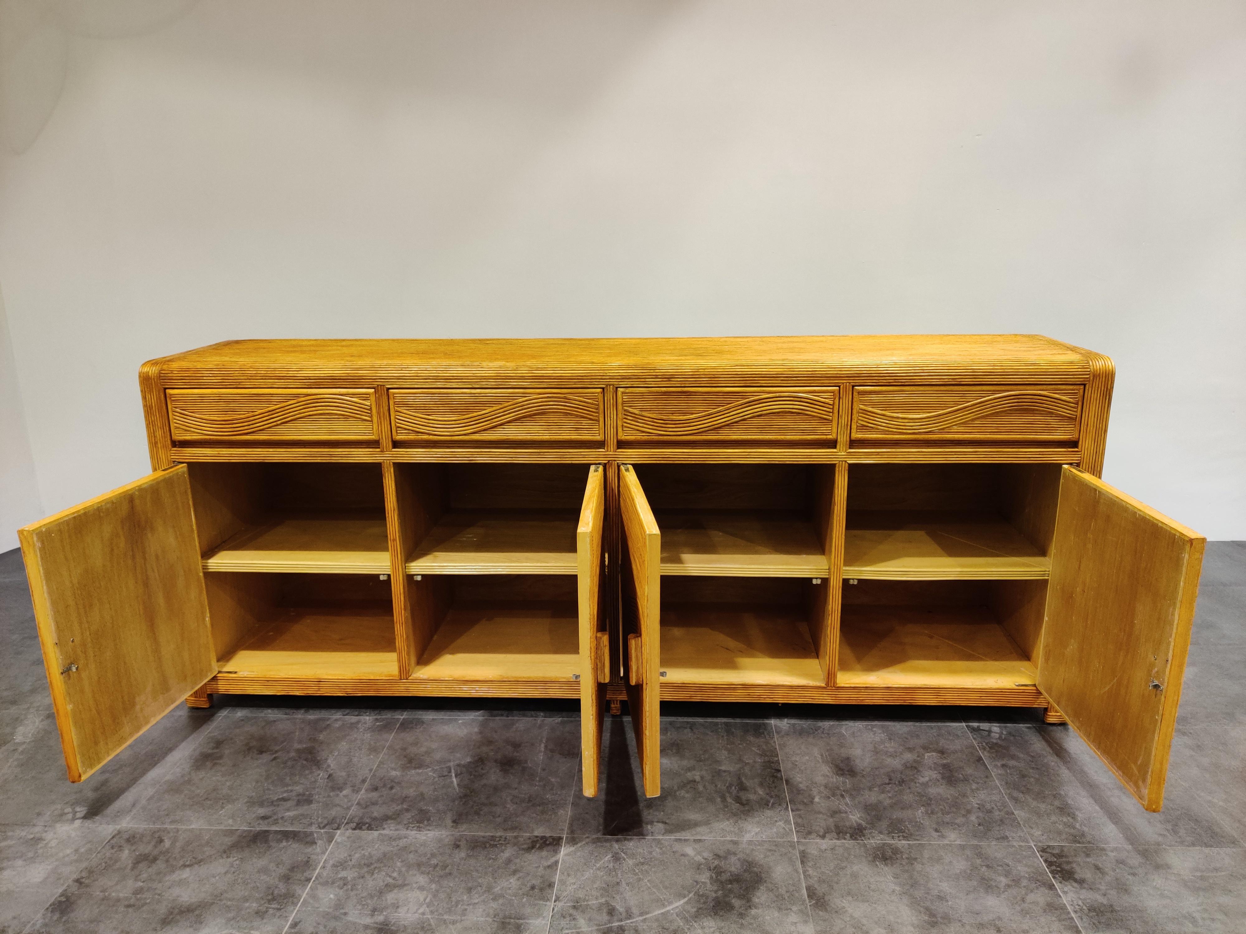 Elegant bamboo and rattan sideboard with four doors and drawers.

Beautiful rounded edge with a wave pattern in the doors and drawers.

Good condition.

1970s, France

Dimensions:

Length 220cm/86.61