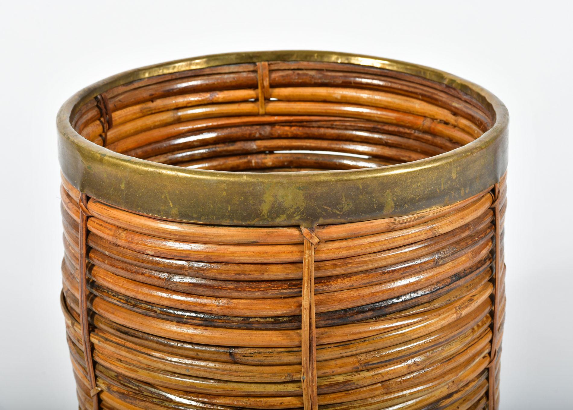 Sturdy rattan log basket or large planter with decorative horizontal wicker trim and brass lip.