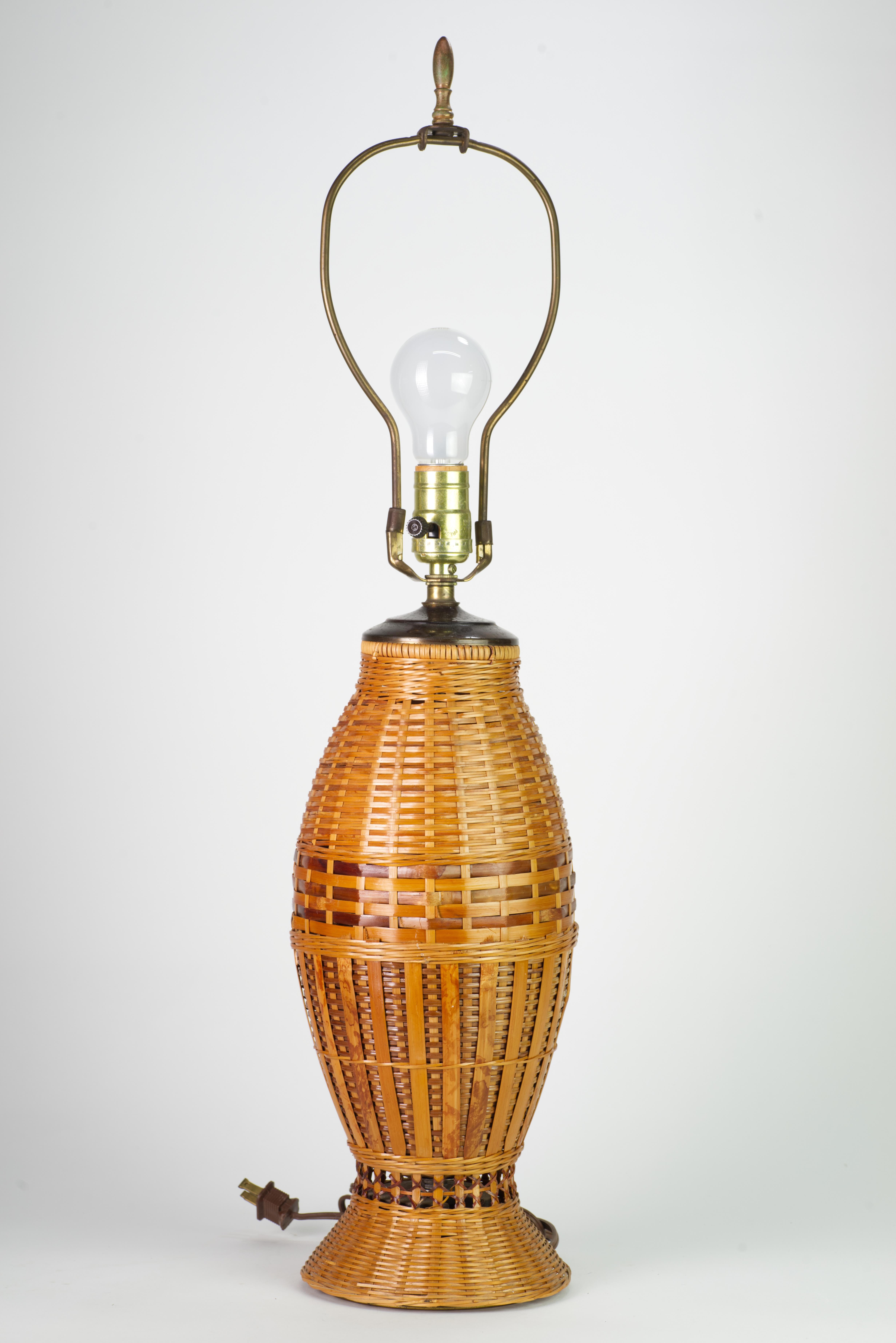  Rare vintage rattan table lamp with bronze top was meticulously hand-woven in combination of patterns. Light variations in rattan's color and complex weave add minimal detailing and textural richness to the piece. Second, bronze base, hidden under