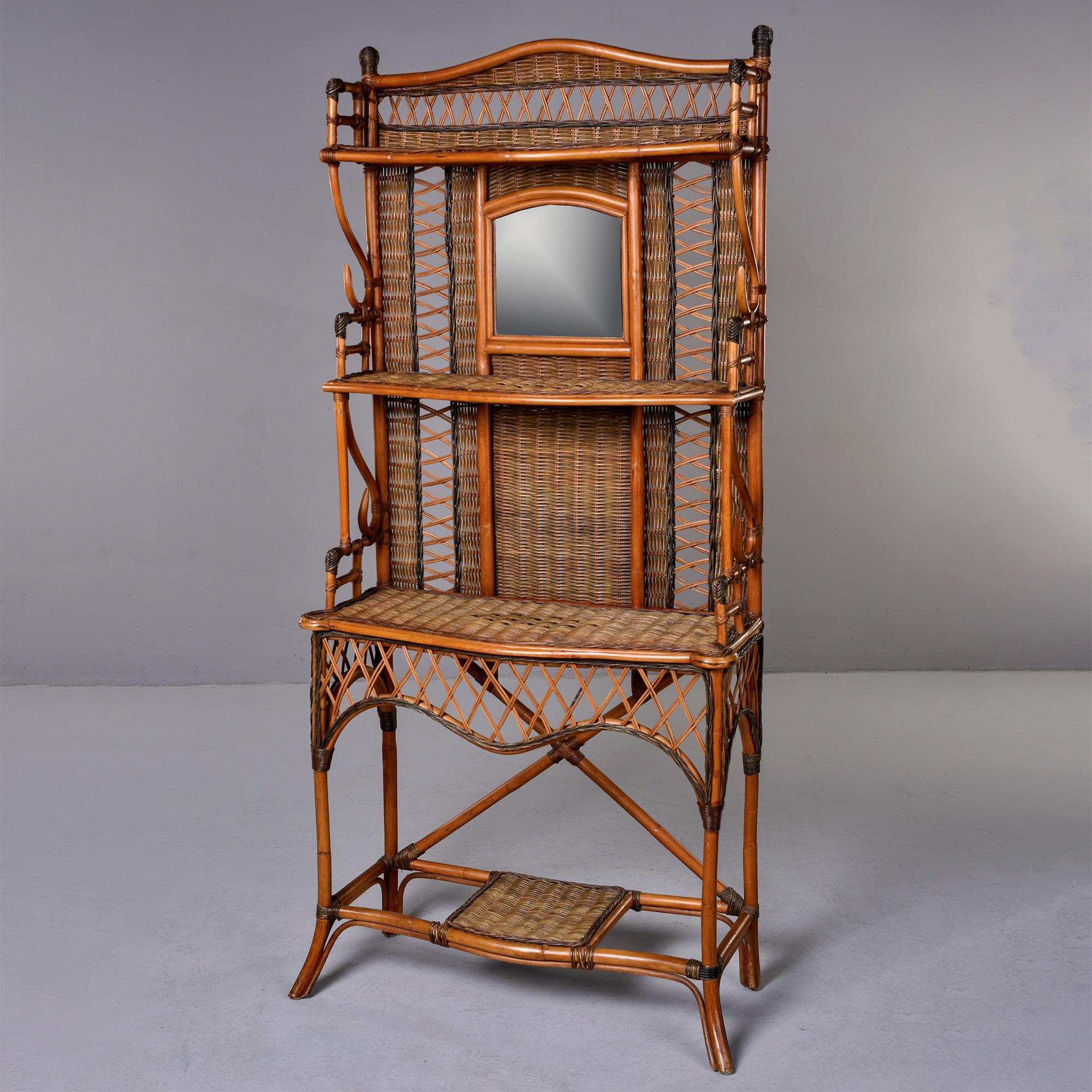 Found in England, this circa 1940s wicker and rattan hall stand has three main shelves on the top portion, a lower shelf that could be used for a potted plant and a mirror. Unknown maker. Very good vintage condition. 

Mirror Size: 9.75” H x 10.5”