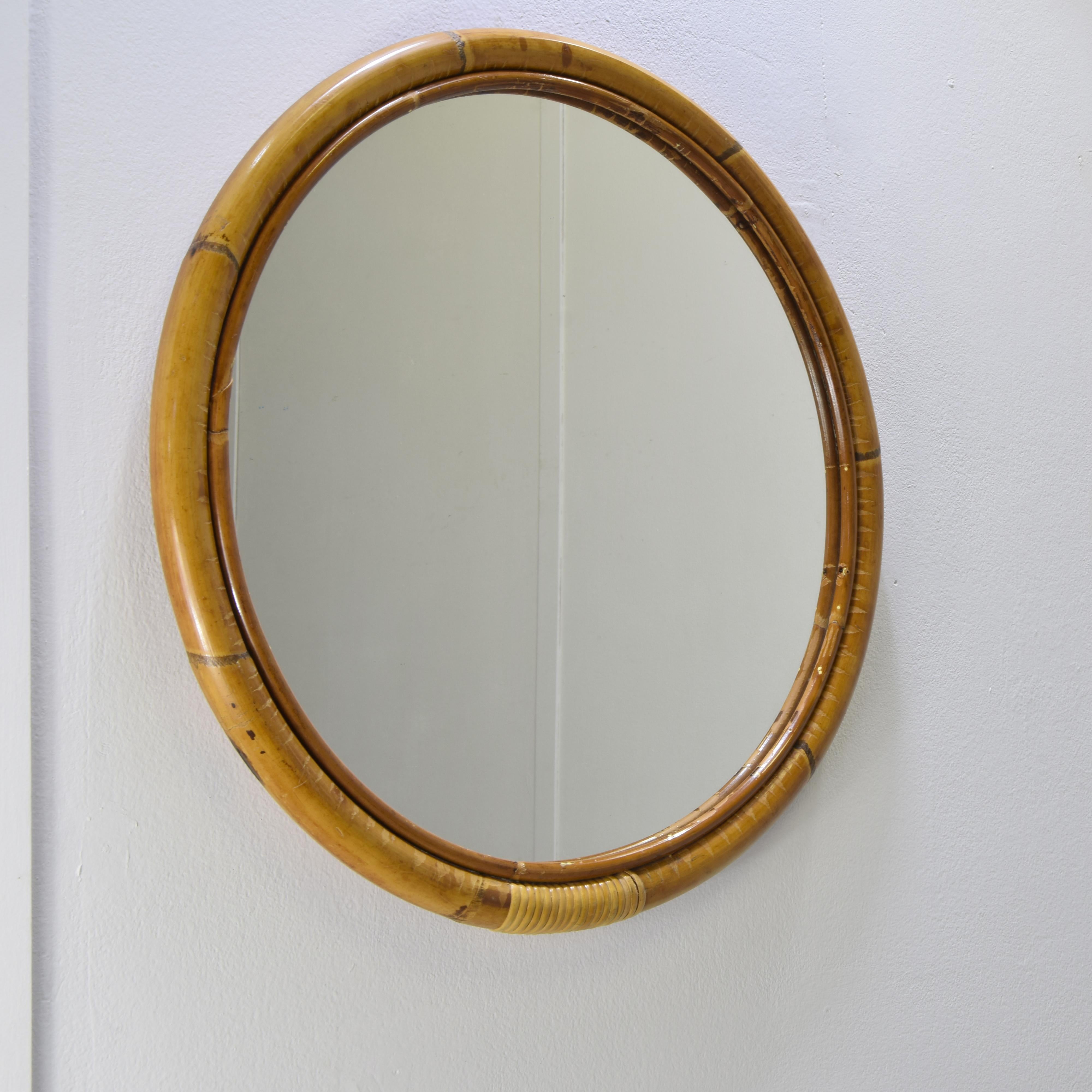 Miroir rond en bambou des années 1970. Le cadre est entièrement fabriqué en bambou et en rotin. Les cannes de bambou sont lisses, d'une couleur naturelle chaude tirant sur le miel ou l'or.

