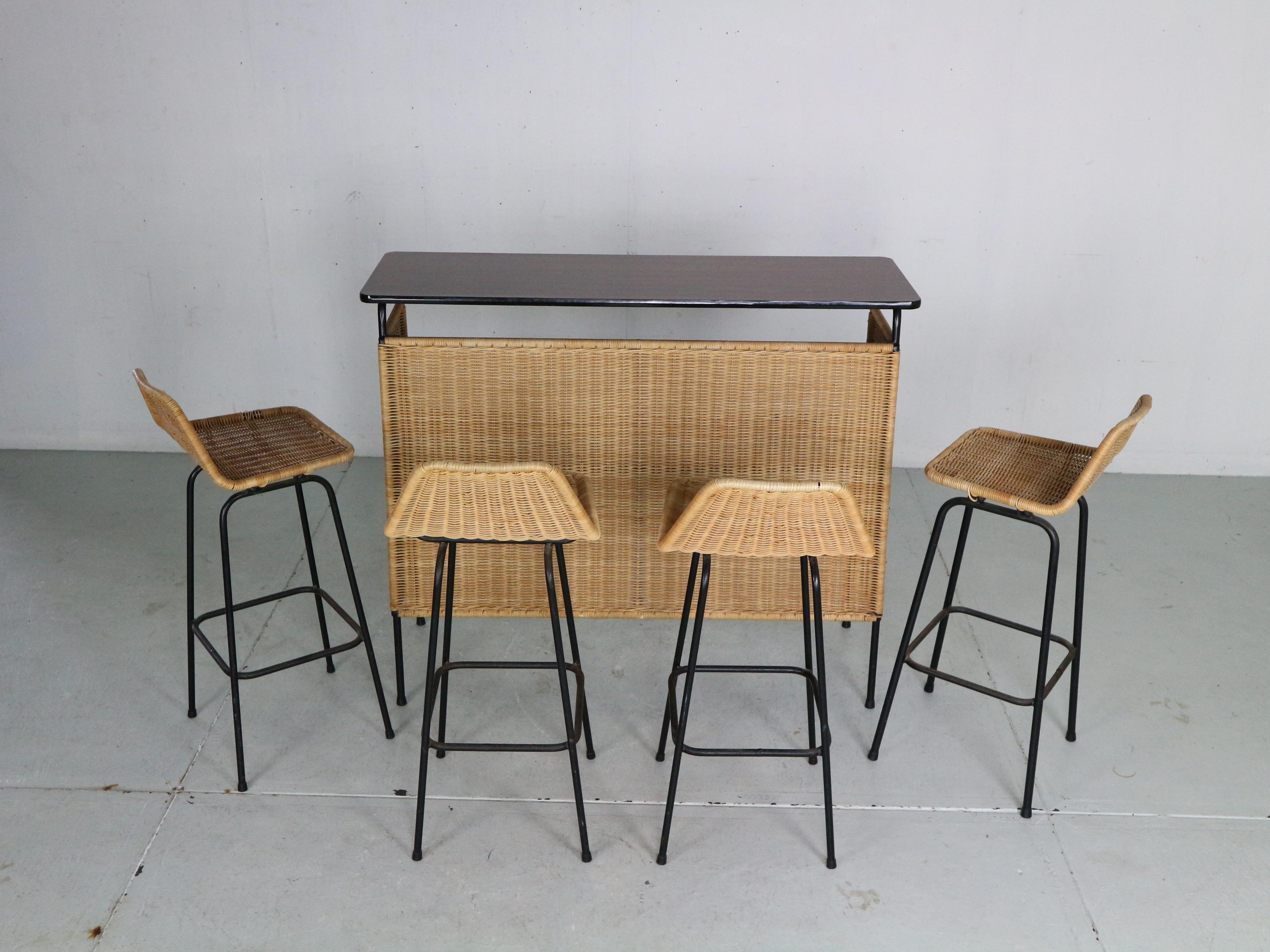 Vintage bar set including the whole bar and 4 bar chairs designed by famous Dutch furniture designer Rohe Noordwolde, 1960's The Netherlands.

The bar is made of the wicker rattan base on a black metal feet.
The two tops- the serving one and one