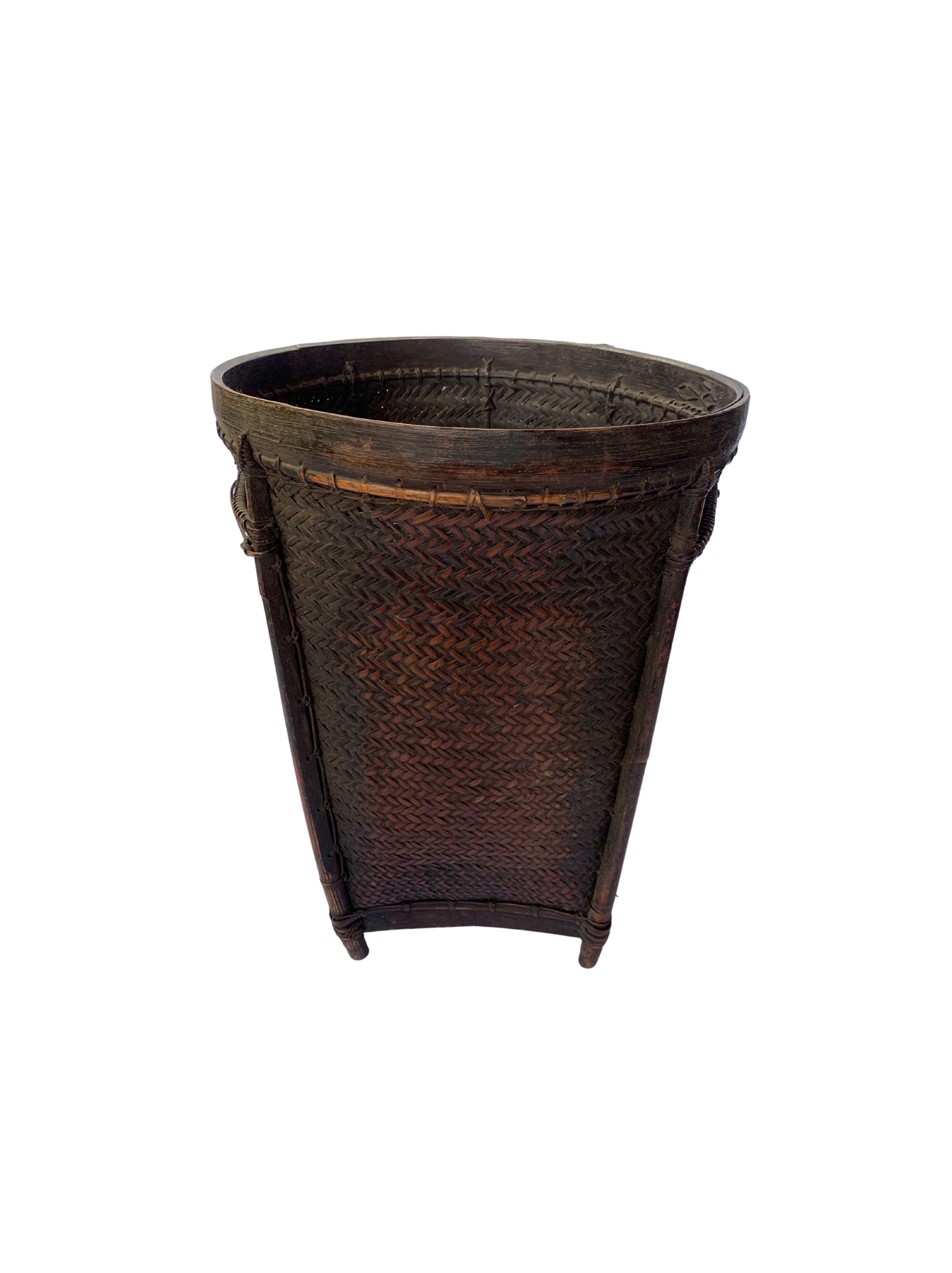 This vintage hand-woven basket originates from the Dayak tribe of Borneo crafted with rattan fibres and an ironwood frame and rim. These baskets are used to carry leaves, fruit, grain and wood. This basket features beautiful extended