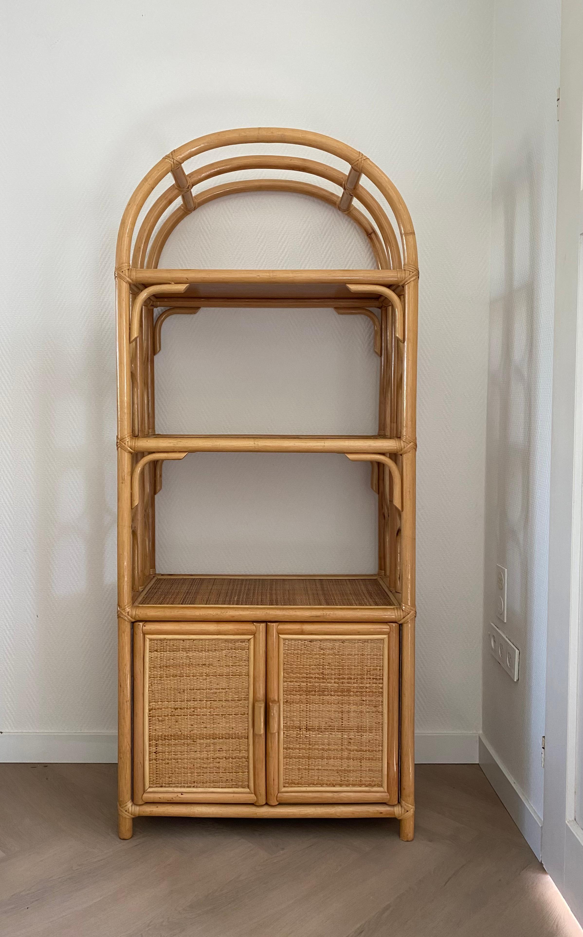 Rattan/Wicker and Cane Bookcase/Cabinet from the late 20th Century.  The shelf inside, which was probably placed by former owners, is missing but easy to replace if needed. The piece remains in good condition with wear consistent with age and use.