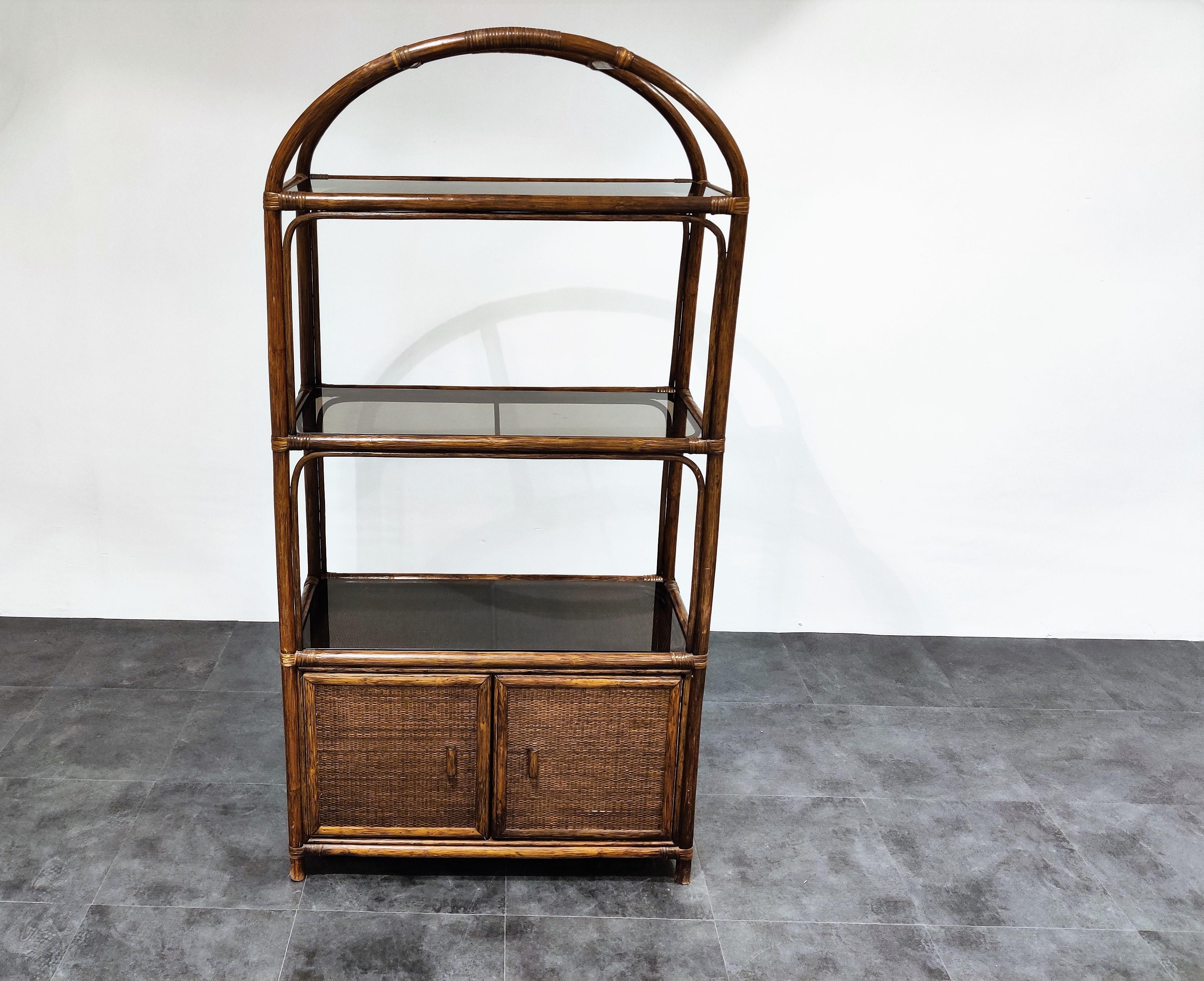 Midcentury rattan and bent wooden étagère or bookcase with two doors.

This étagère has also 3 smoked glass shelves.

Great piece for in a bathroom, entryway or living room.

Good condition.

1970s, Netherlands

Dimensions:
Height