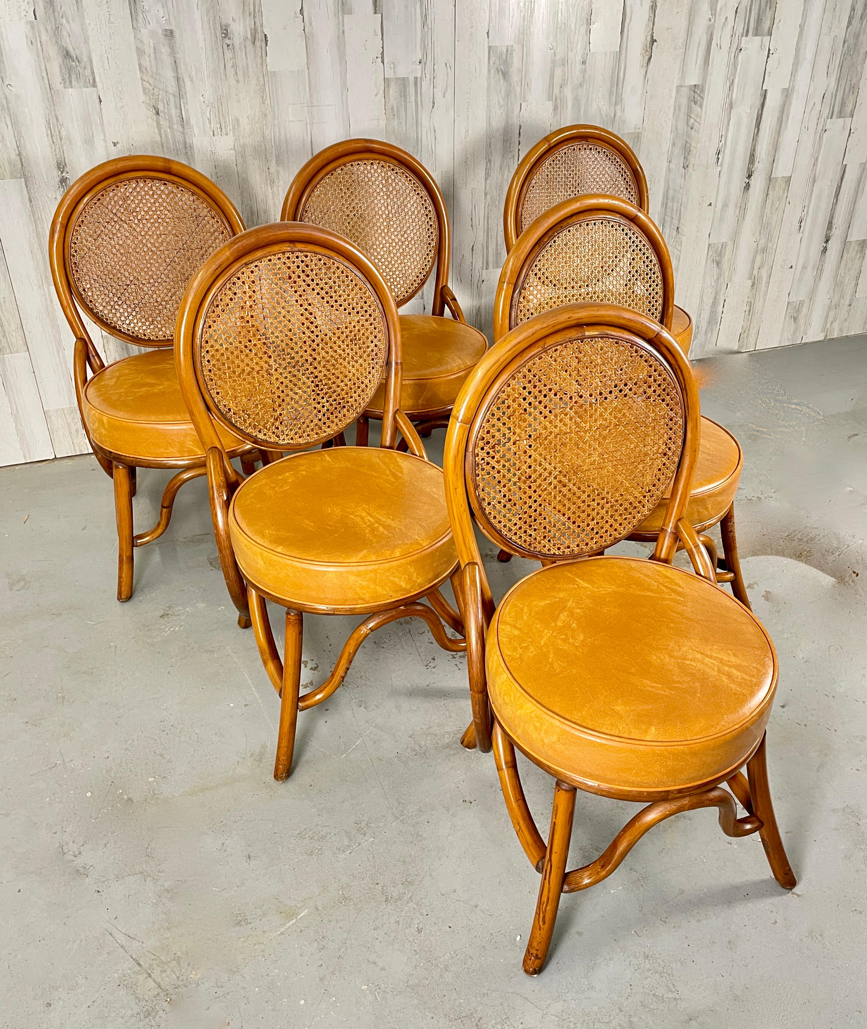 Rattan & woven cane back dining chairs. These chairs have a very nice original cognac naugahyde seats.