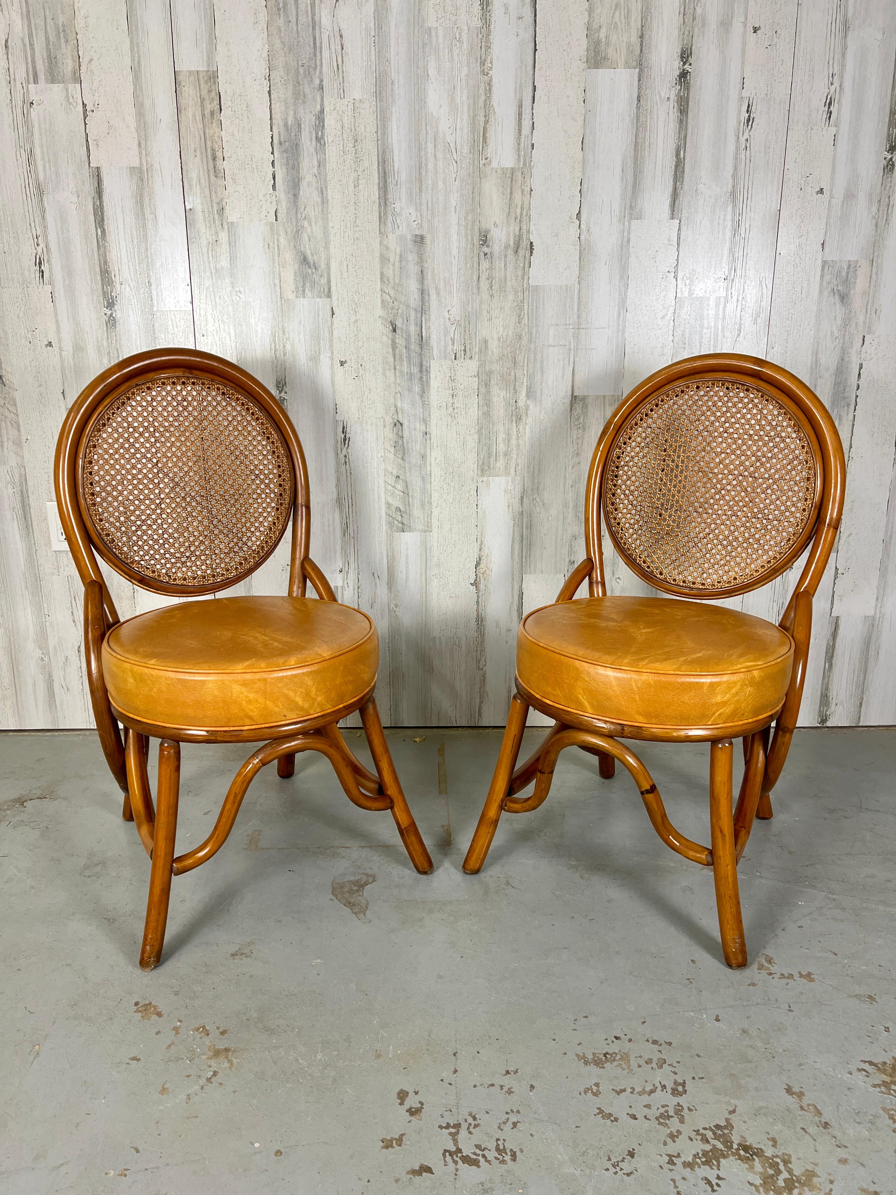 Rattan & woven cane back dining chairs. These chairs have a very nice original cognac naugahyde seats.
