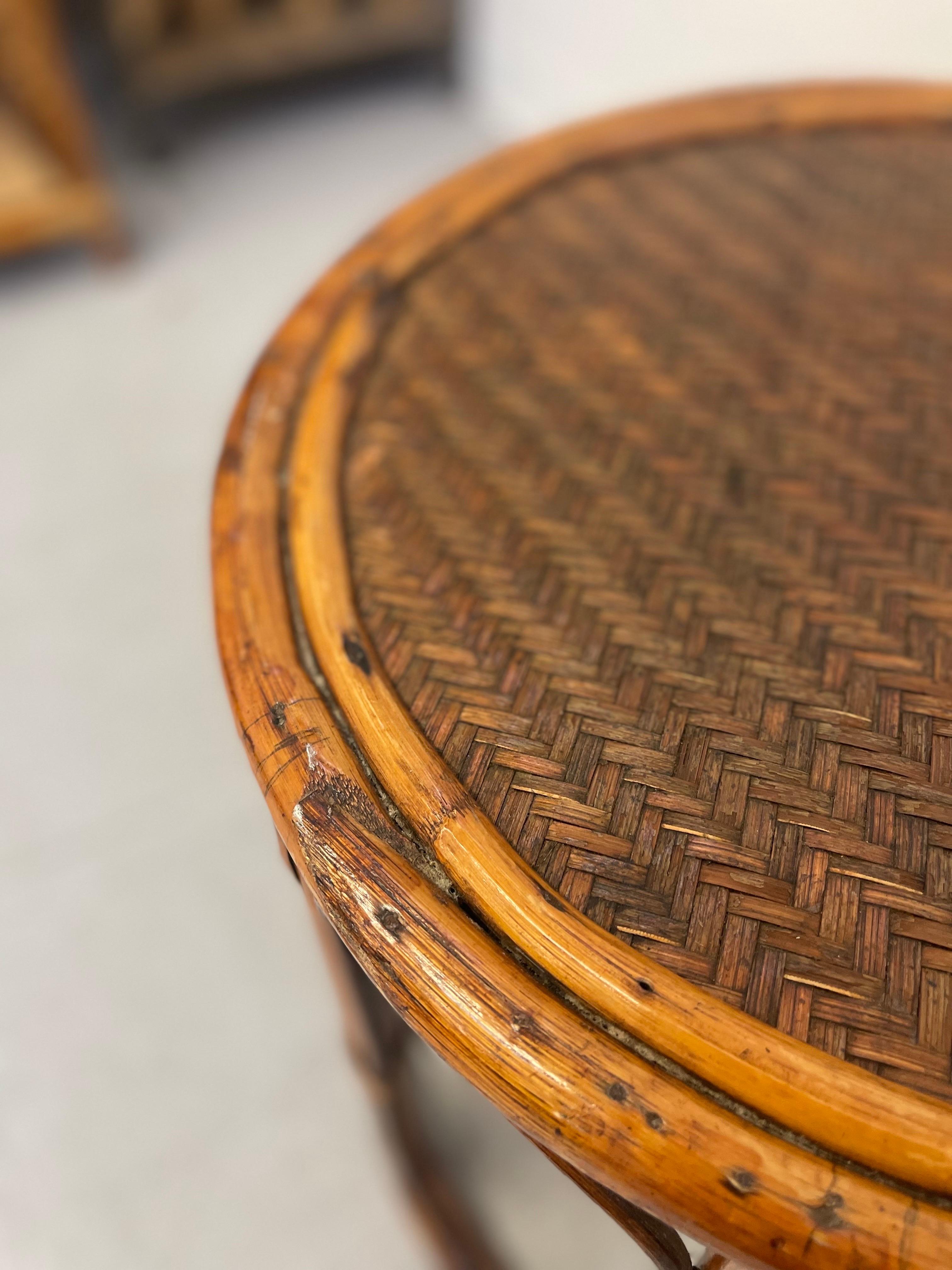 Woven top side table with caning on the base. Possibly bamboo or bent wood. Round shape.
Vintage condition consistent with age as pictured.