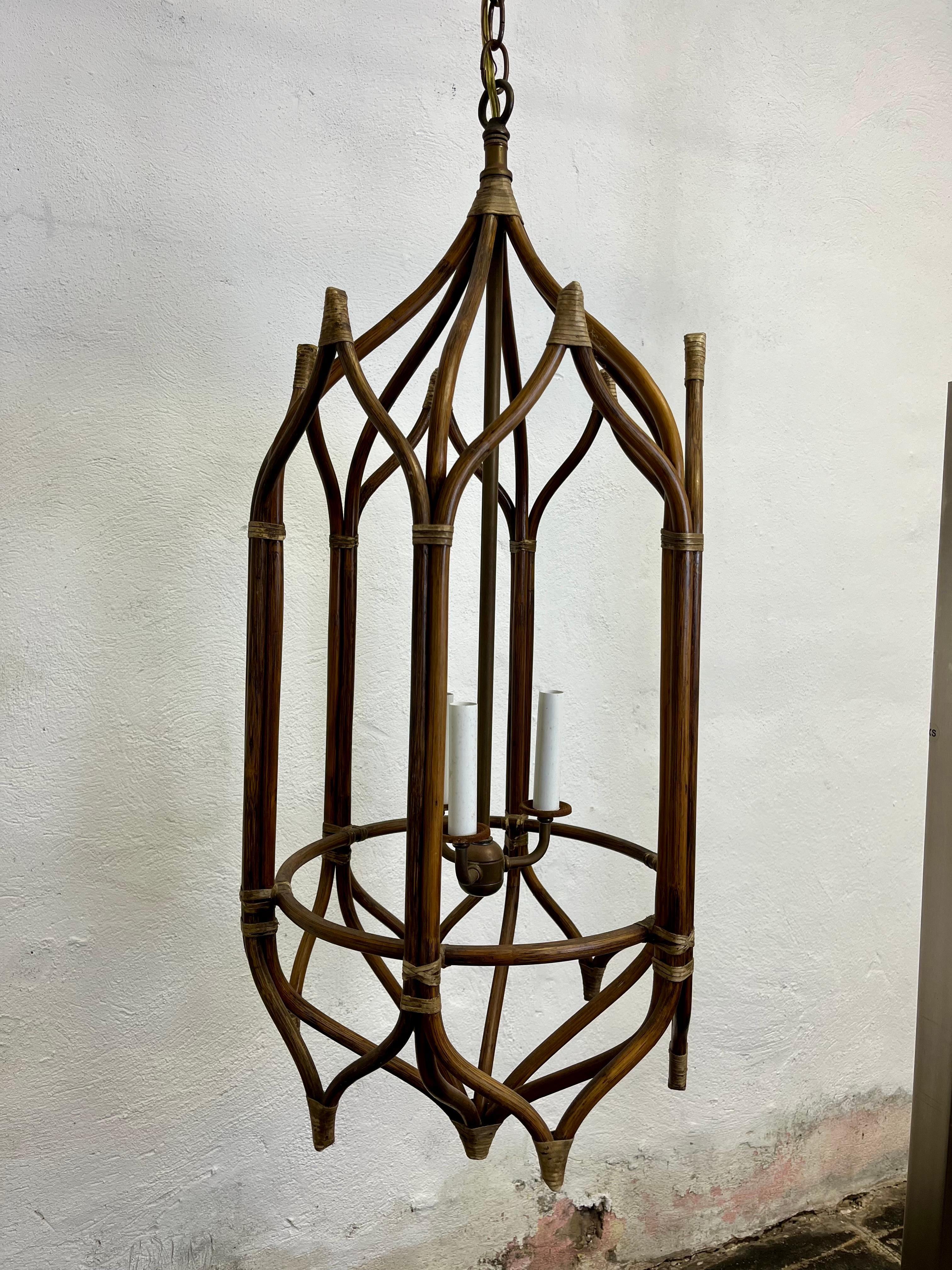 Spectacularly unique hexagon rattan chandelier in a pagoda or cathedral manner. Thin rattan wrapped in leather surrounding 3 lights on brass stem. Perfect for a coastal bo-ho chic decor. Crespi vibes.
I have 3 available.