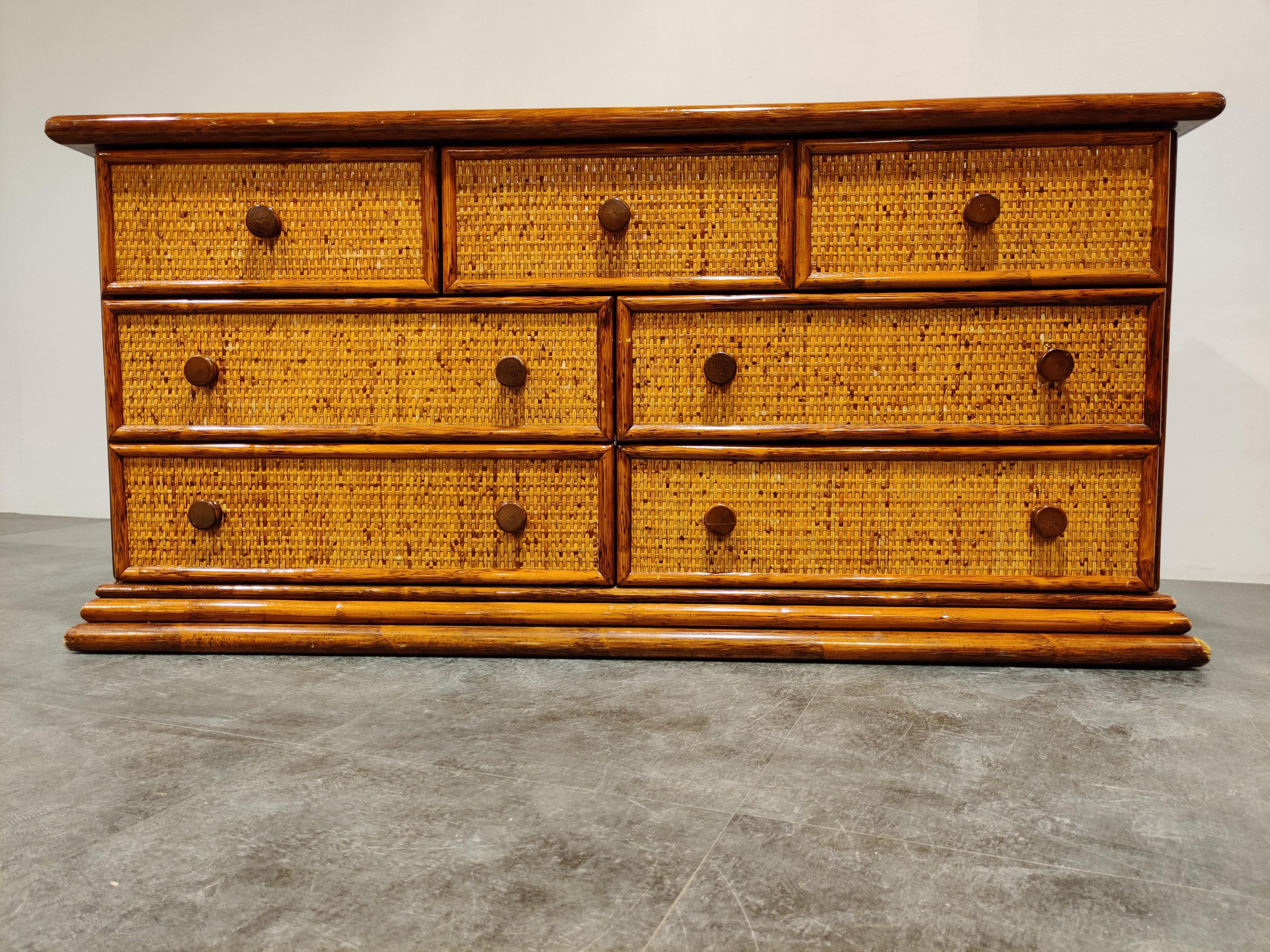 Elegant wooden and rattan chest of drawers with 7 drawers.

Produced by Maugrion, delivering quality rattan furniture and sold in high segment furniture shops such as Roche Bobois.

Beautiful color and lovely handles.

Good condition, slight