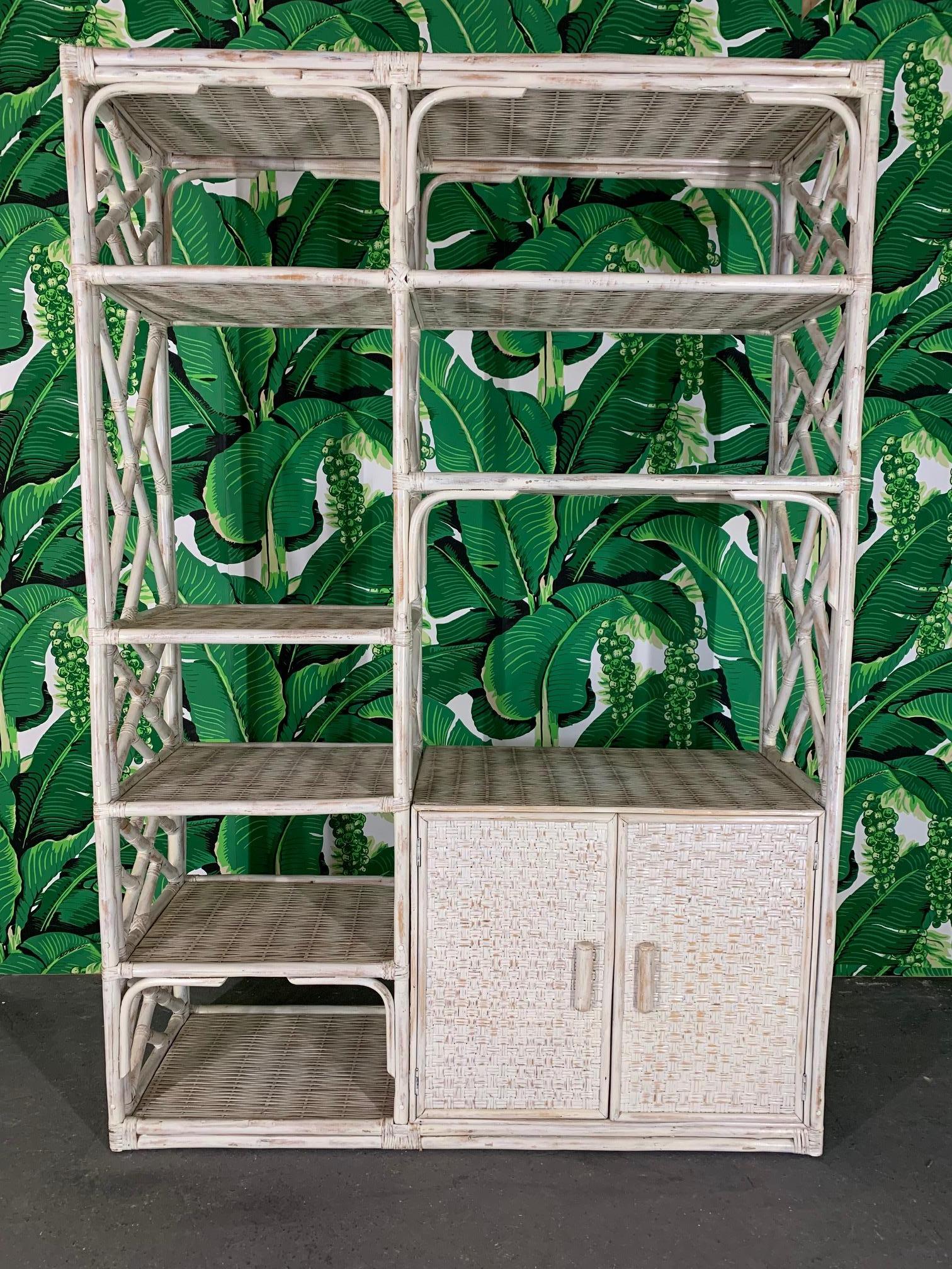 Vintage rattan étagère features chinoiserie detailing and a white washed finish. Ample shelving and extra storage behind double doors. Good vintage condition with minor imperfections consistent with age.