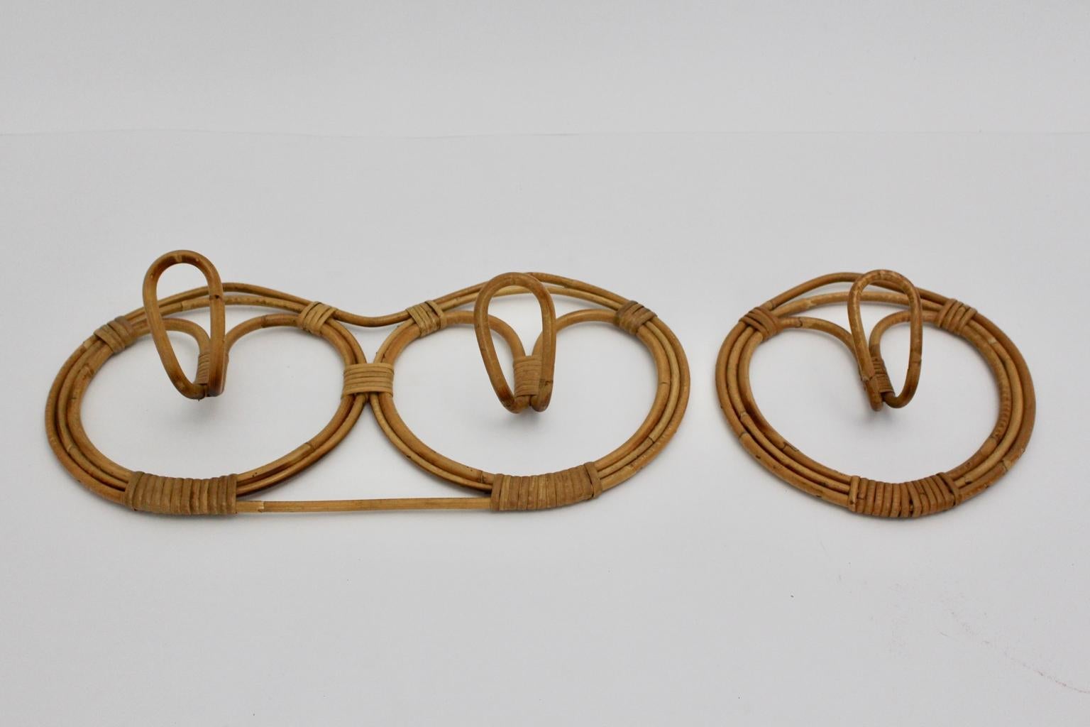 This set of vintage rattan coat hooks was designed in Italy, 1960s.
The charming rattan set consists of two pieces, one double coat hook and one single coat hook. 
The color of the rattan set is beautiful through its brown tone.
Very good vintage