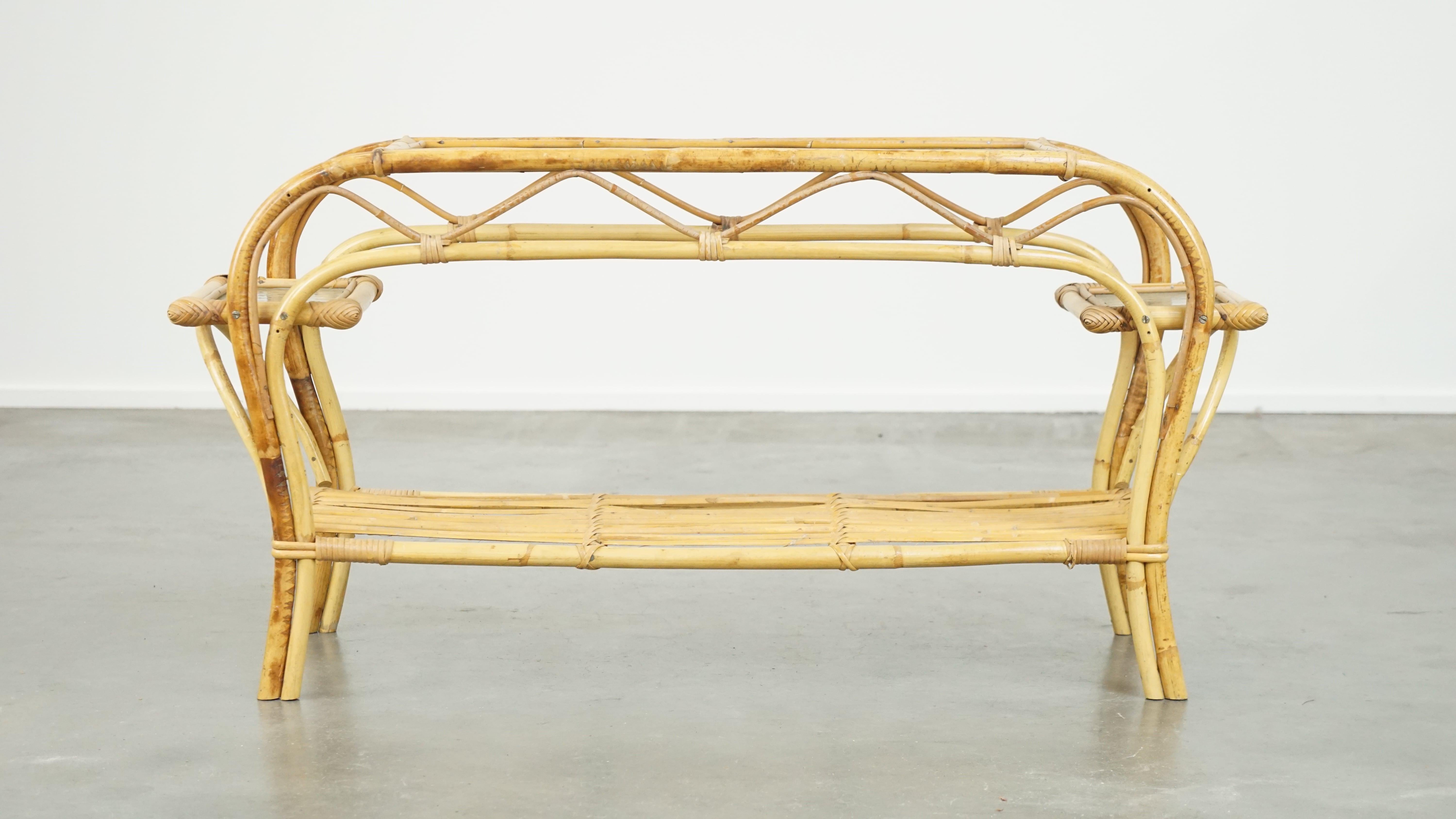 Questo affascinante tavolino vintage presenta tre piani in vetro a forma di nuvola e una bellissima struttura in rattan. Prodotta negli anni '50 da Rohé Noordwolde, si adatta facilmente a quasi tutti gli stili di interni, sia all'interno che