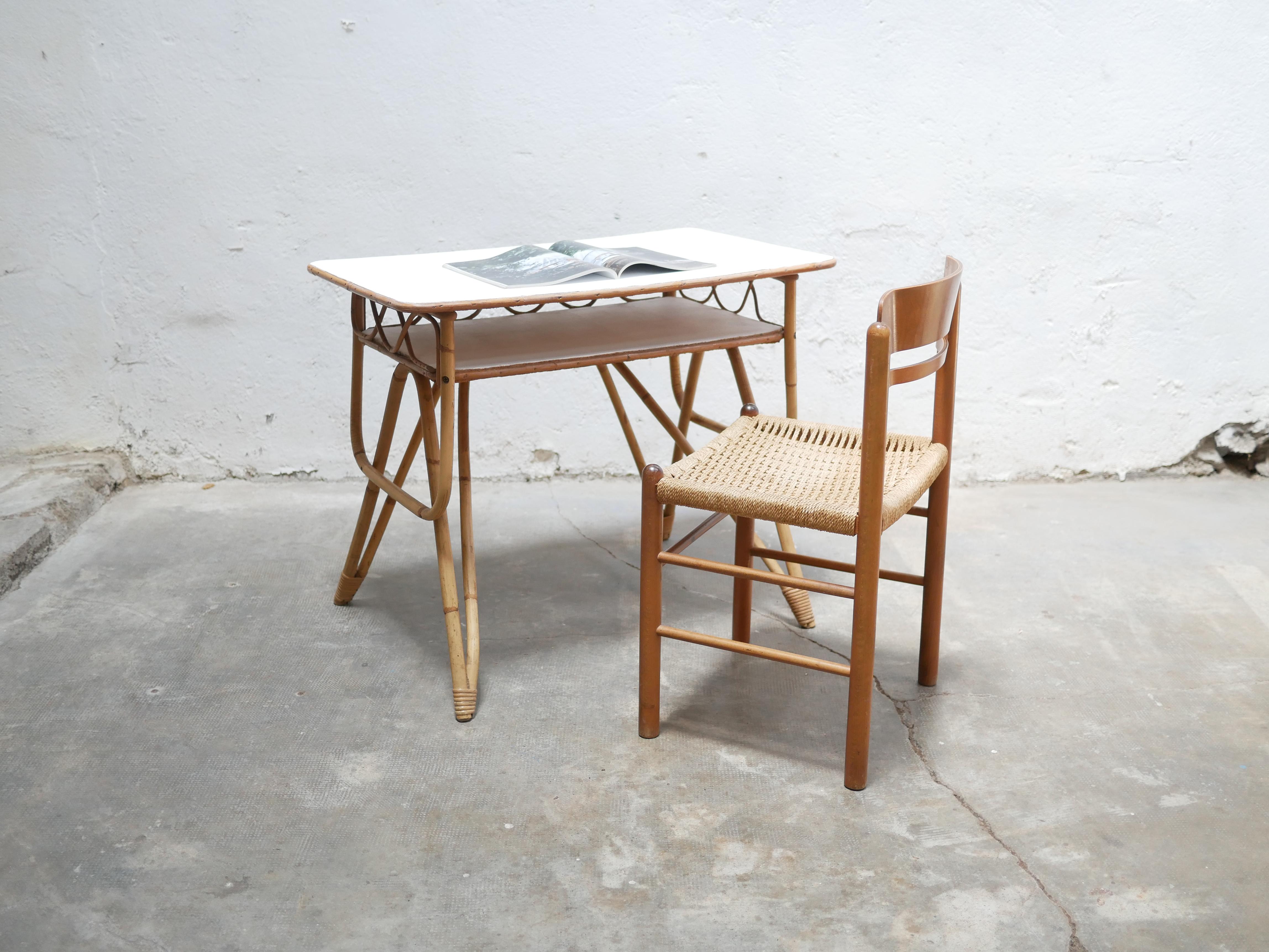 Scrivania in rattan degli anni '60. 

Il piano e il ripiano sono verniciati in bianco velluto opaco, la tonalità luminosa e calda del rattan. 
Le curve della scrivania sono morbide e armoniose.

Trendy, pratico ed estetico, l'ufficio non manca di