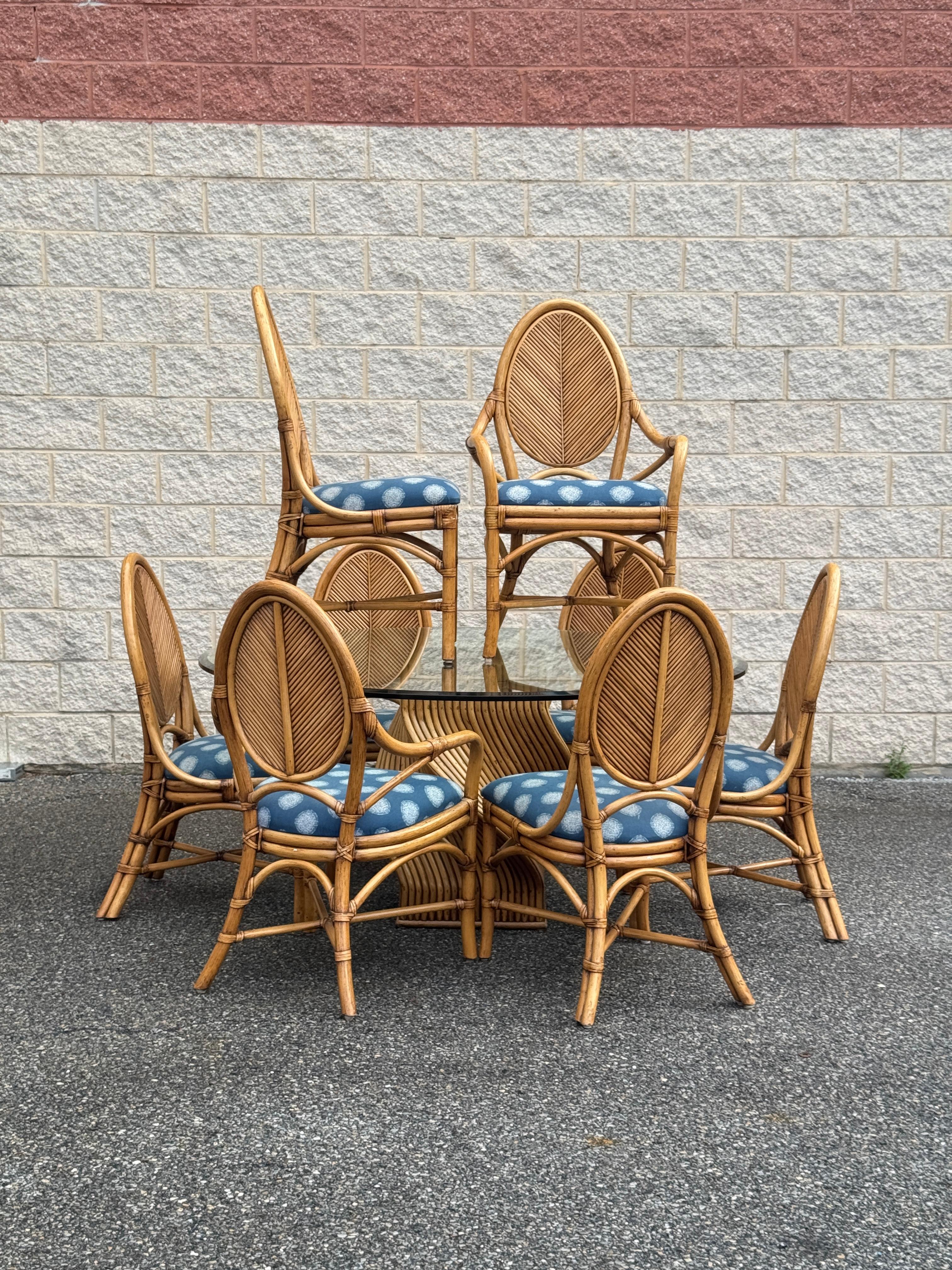 Ensemble de salle à manger vintage en rotin 9 pièces comprenant une table ronde à plateau en verre et huit fauteuils assortis. Construit en rotin de bois courbé avec une finition naturelle, l'ensemble met en valeur le design tropical et côtier du