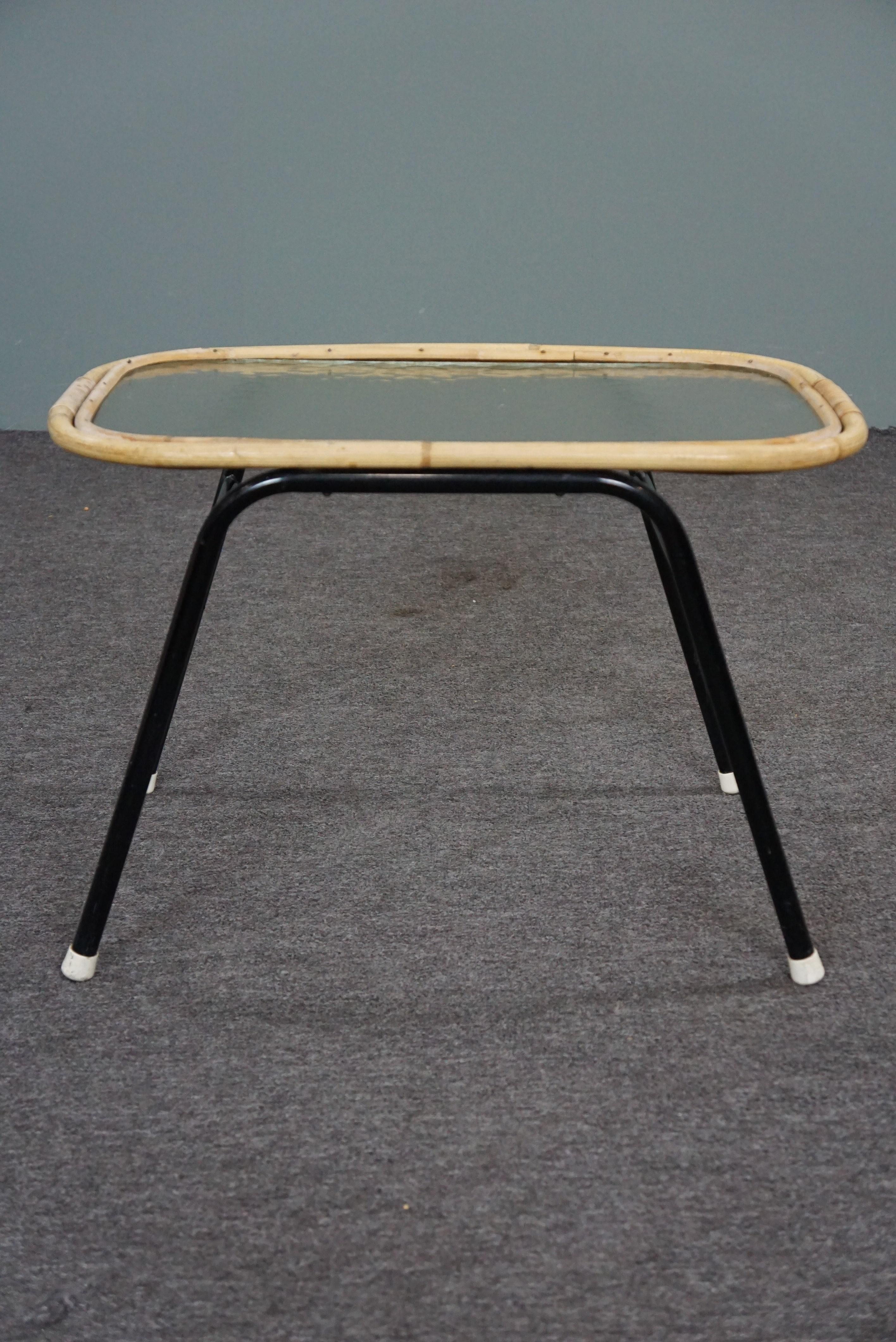 Offered is this beautifully designed rattan coffee table made in the 1960s in the Netherlands.

This beautiful rattan side table has a cloud glass top, a subtle design and black metal legs.

This table was handmade in the 1960s from high-quality