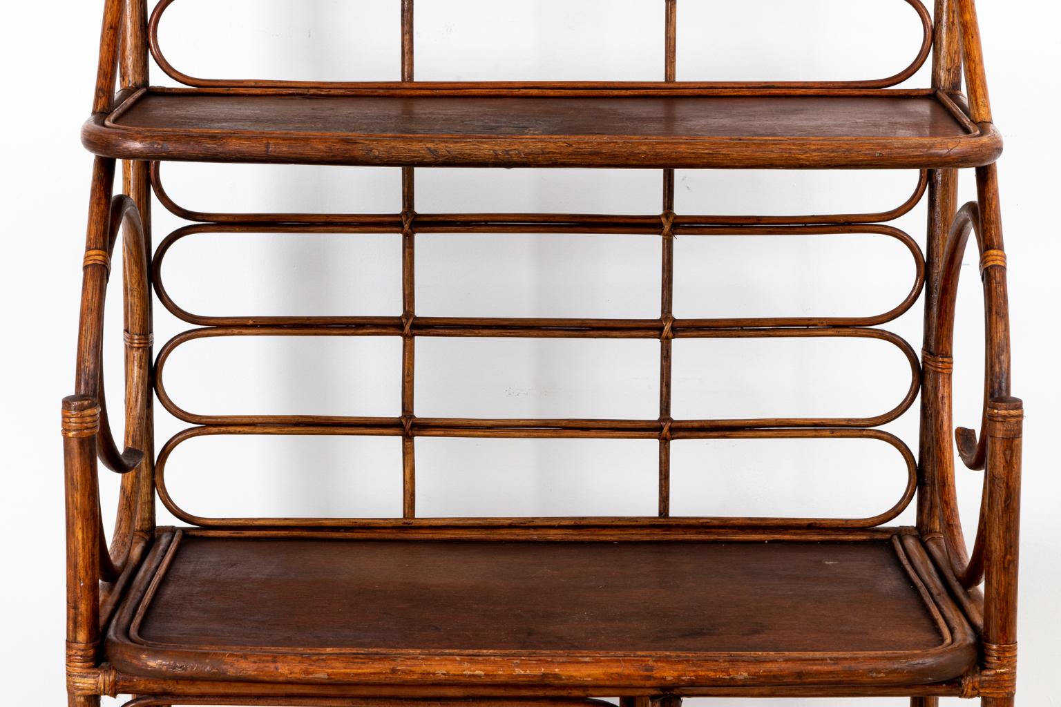 Vintage rattan étagère with deep shelves and scrolled rattan in the Hollywood Regency style, circa 1960s-1970s. The piece comes with large shelves and small bottom shelves. Please note of wear consistent with age as seen through minor finish loss on