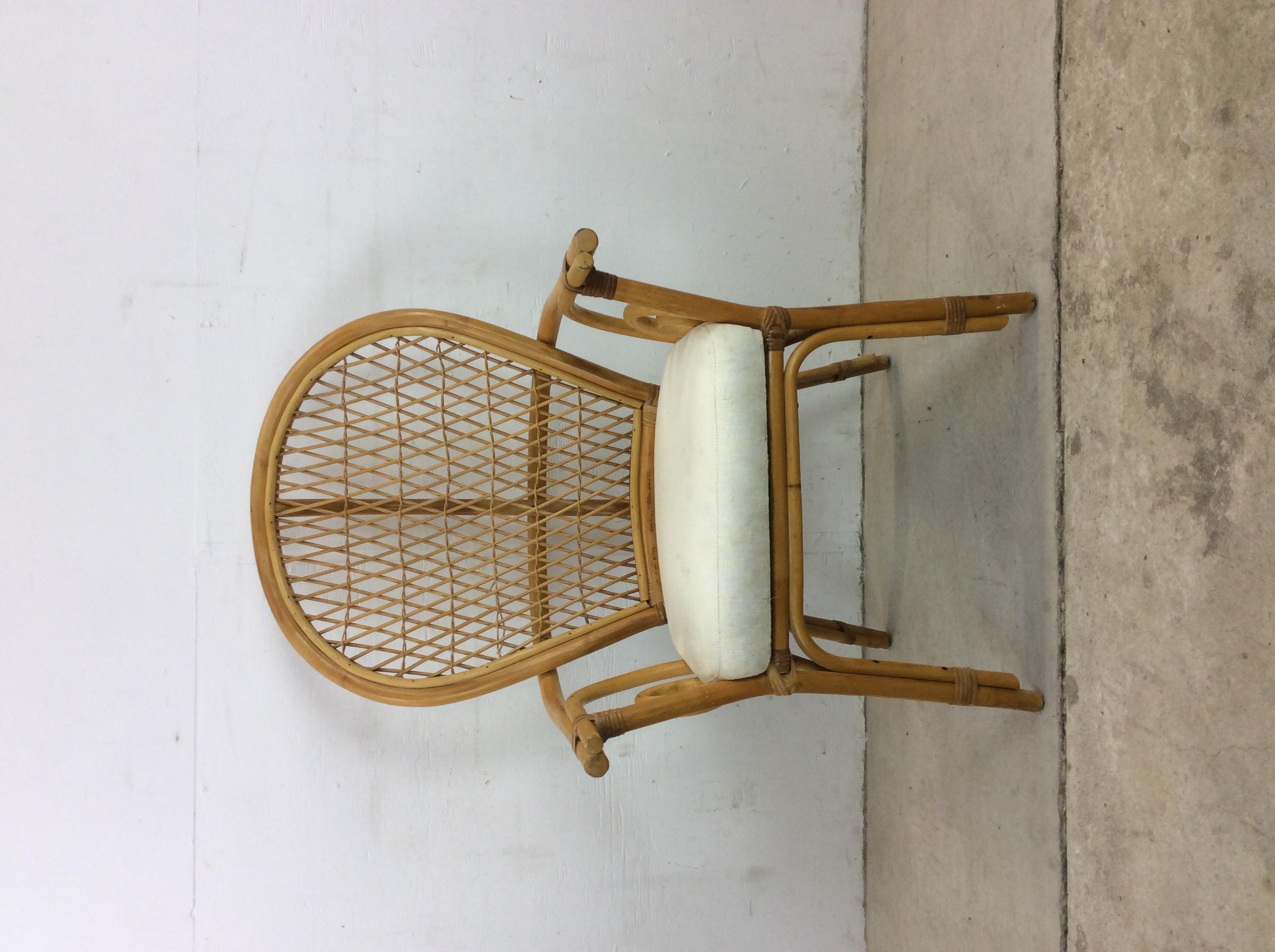 Cette chaise vintage en rotin des années 1970 présente un large dossier en éventail, des détails uniques sur les bras et une assise vintage recouverte de tissu blanc.

Dimensions : 26.5w 25d 44h 18.5sh.
 