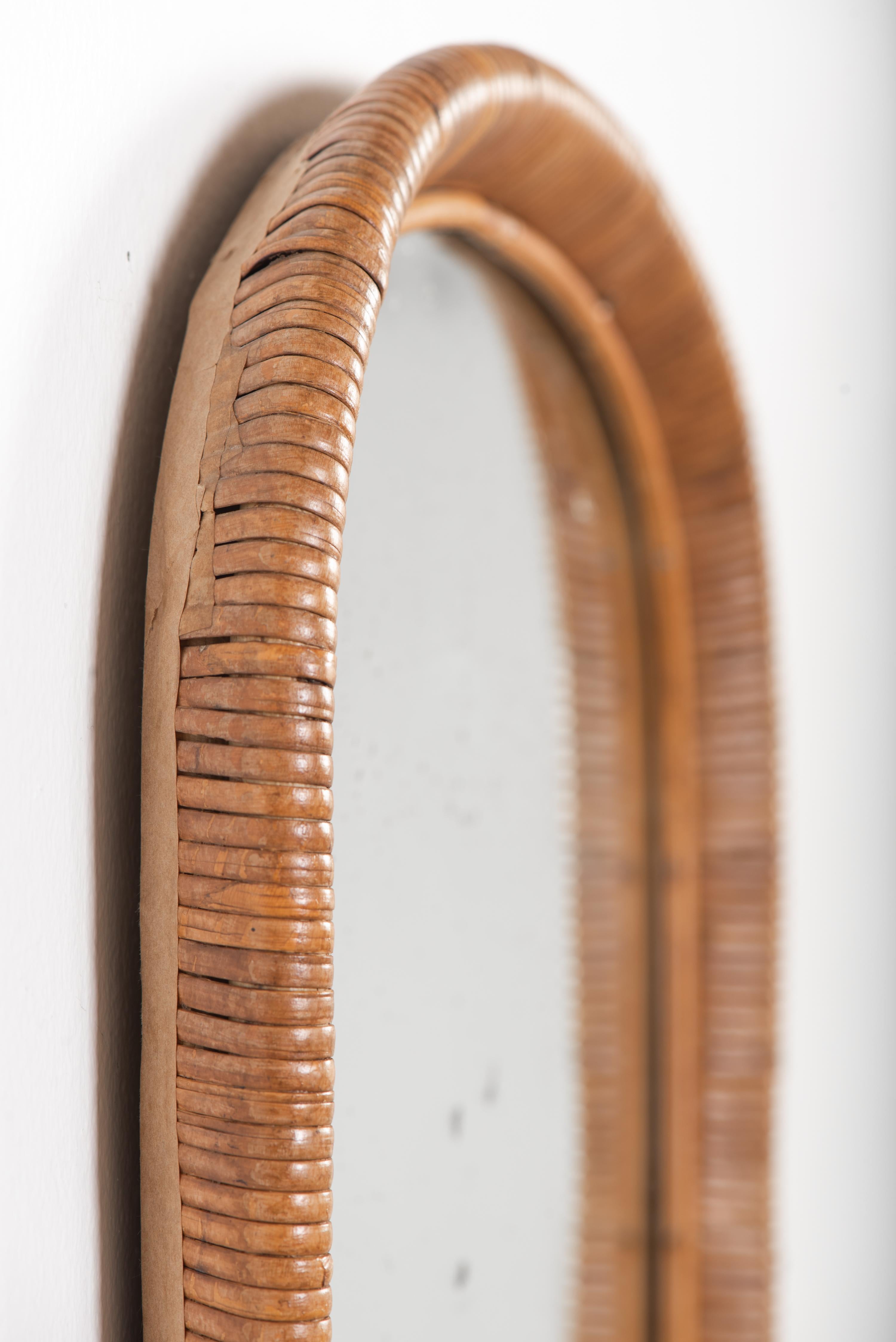 Specchio classico della metà del secolo scorso realizzato a mano con rattan di alta qualità, con la patina vintage più perfetta che solo il tempo può creare. Una scoperta rara! Realizzato da Sokeva Oy per Artek negli anni '60, questo pezzo senza
