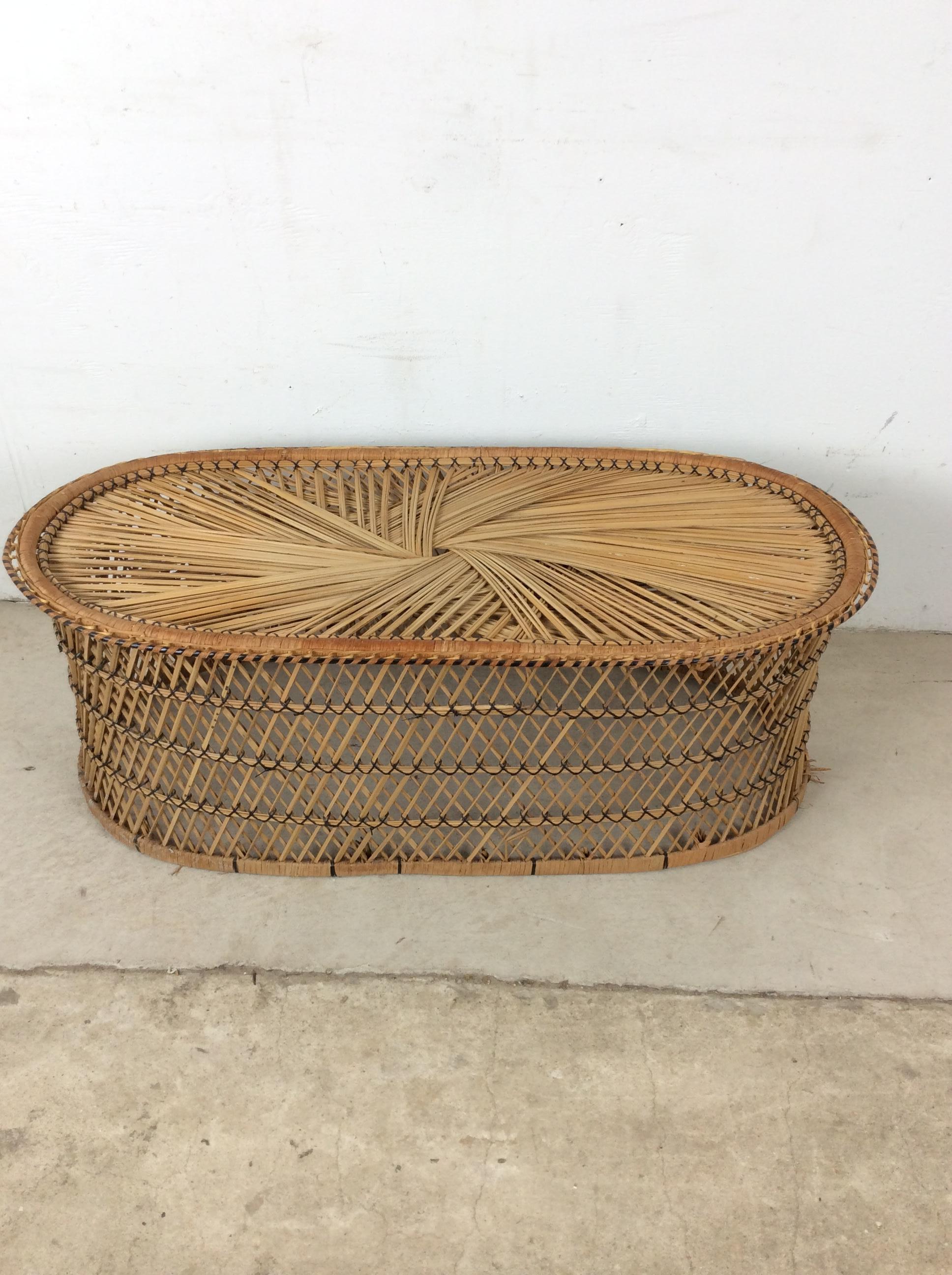 Cette table basse vintage boho chic présente une construction en rotin, une finition originale et un design de forme ovale.

Dimensions : 40w 8.5d 14.75h 

Notes sur l'état : Meuble en rotin globalement robuste avec un peu d'effilochage à la base et