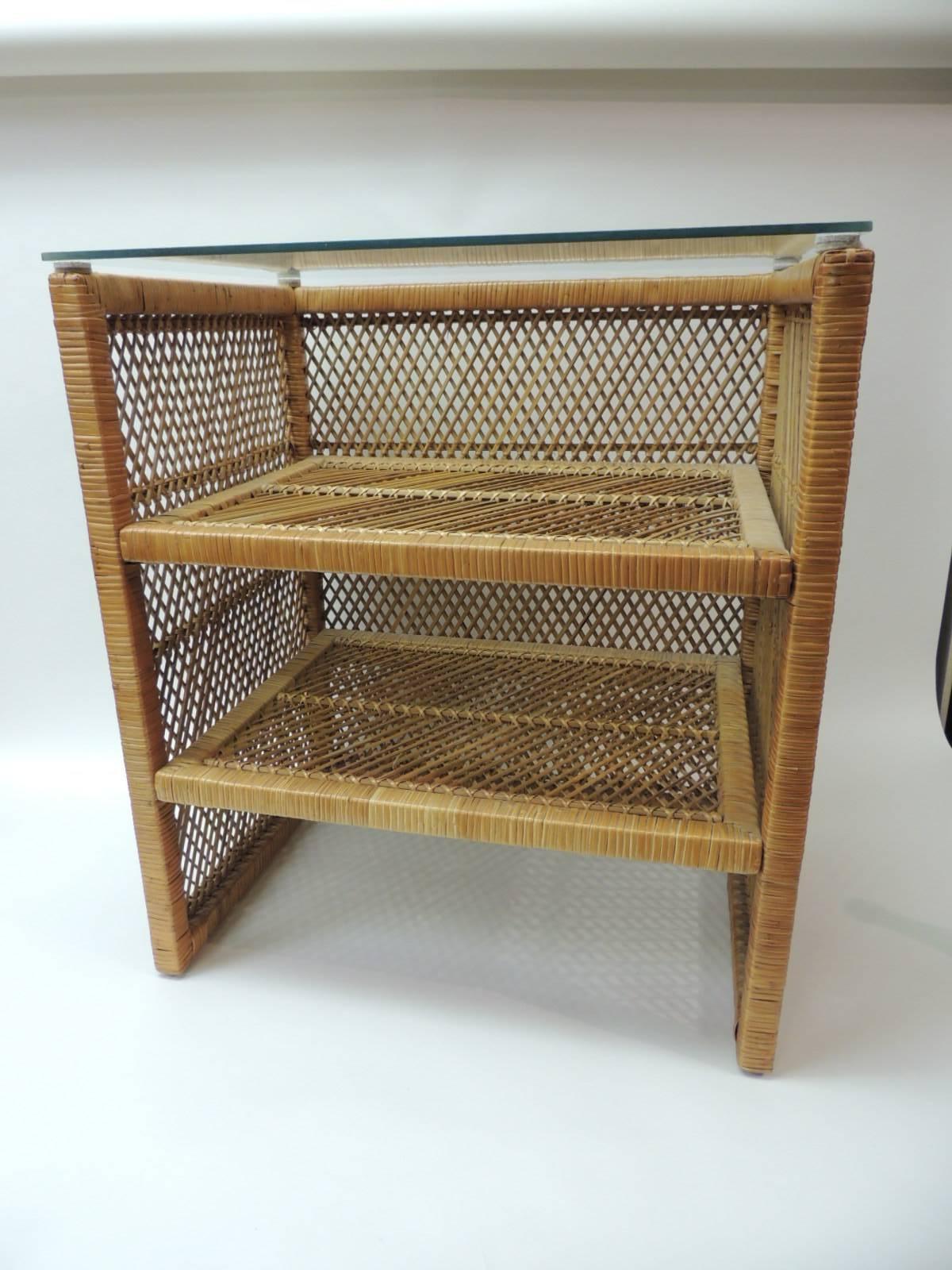 Vintage rattan and wicker rectangular side table with clear glass top.
All the shelves are woven, like all three sides.
Size: 16 x 22 x 25 H.
