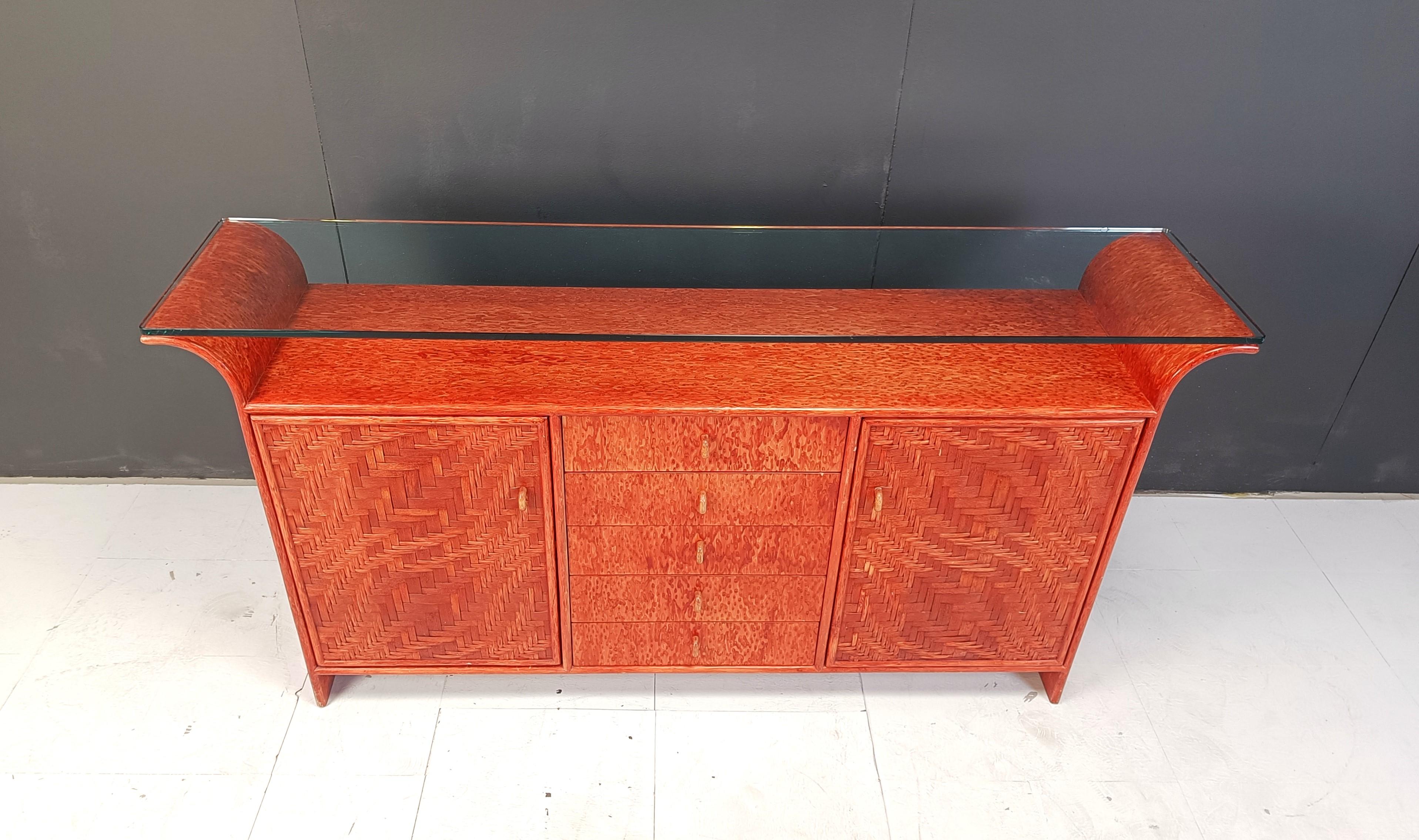 Elegante credenza con ante in rattan intrecciato, 5 cassetti centrali e un bel piano curvo in legno e vetro.

La credenza offre molto spazio per riporre gli oggetti e si adatta a interni bohémien, mediterranei, ecclettici....

Bellissimo colore