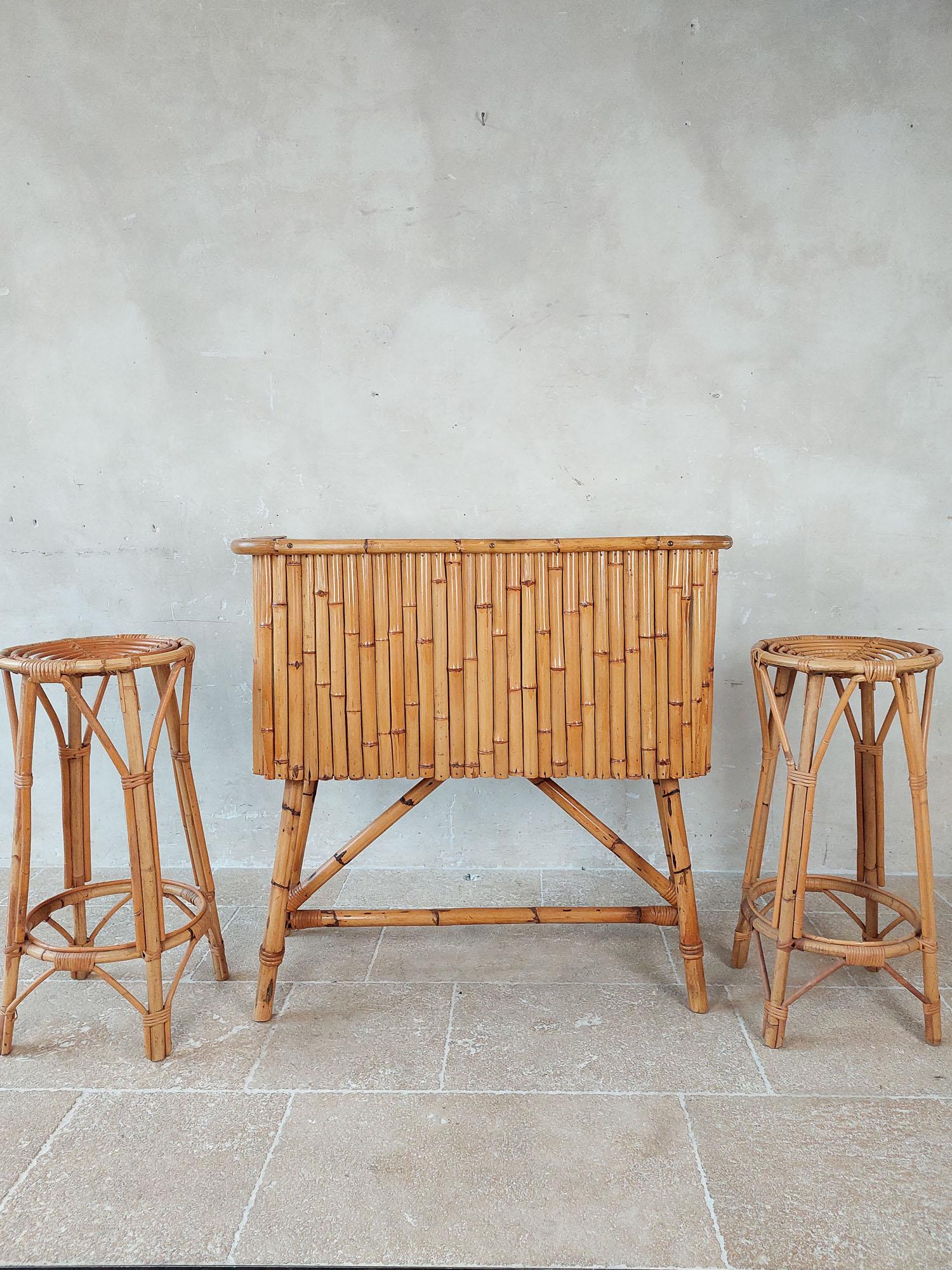 Vintage rattan Tiki bar set with two rattan stools. Charming bamboo dry bar / cocktail bar with black top.

bar dimensions: h 100 x w 107 x d 46 cm
dimensions bar stools: h 78 x diameter 38 cm