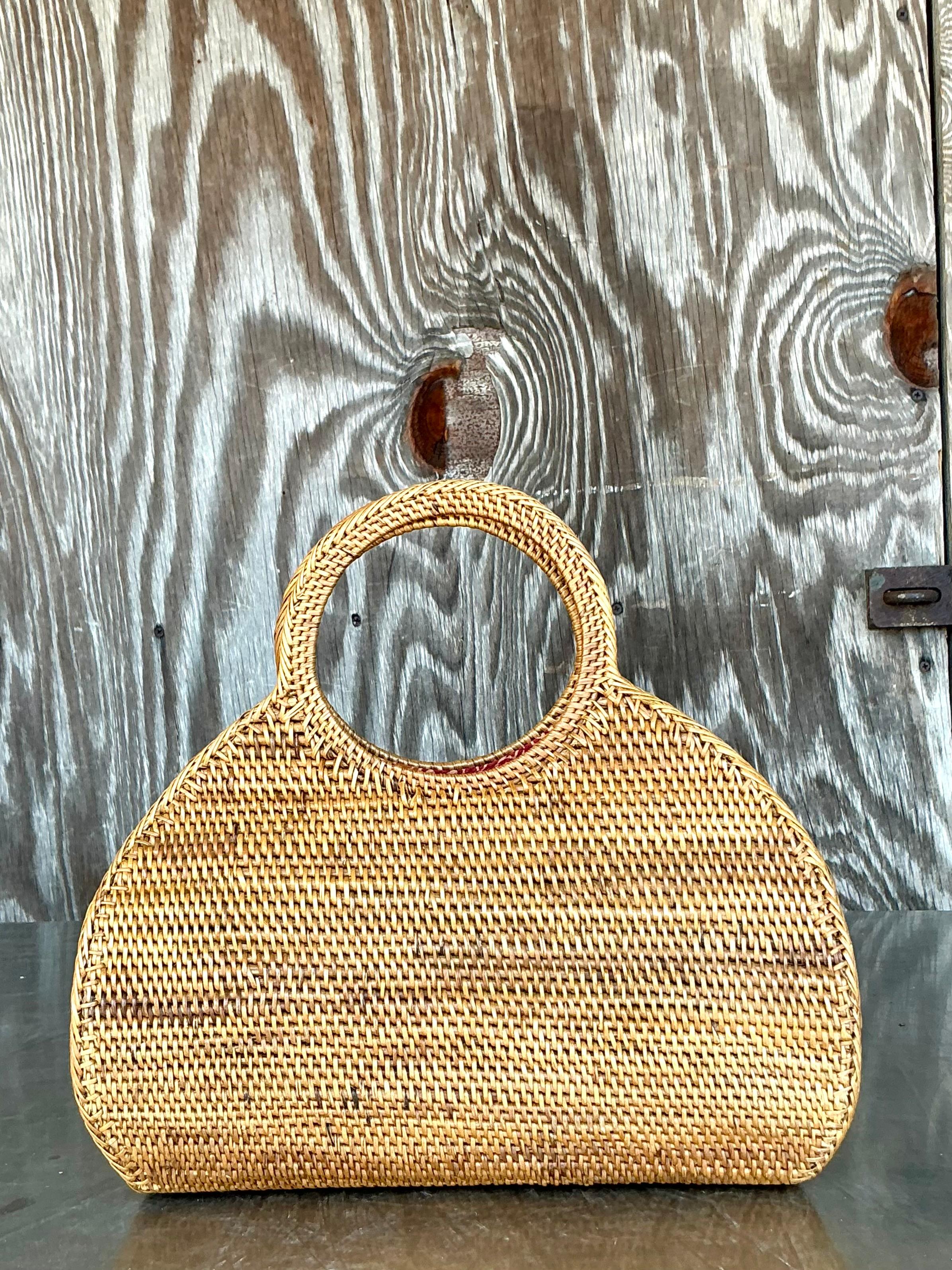 Ajoutez une touche de charme intemporel à votre garde-robe avec ce sac fourre-tout en rotin vintage magnifiquement fabriqué à la main. Fabriqué en rotin naturel et durable, ce sac allie élégance rustique et design fonctionnel, parfait pour tous ceux