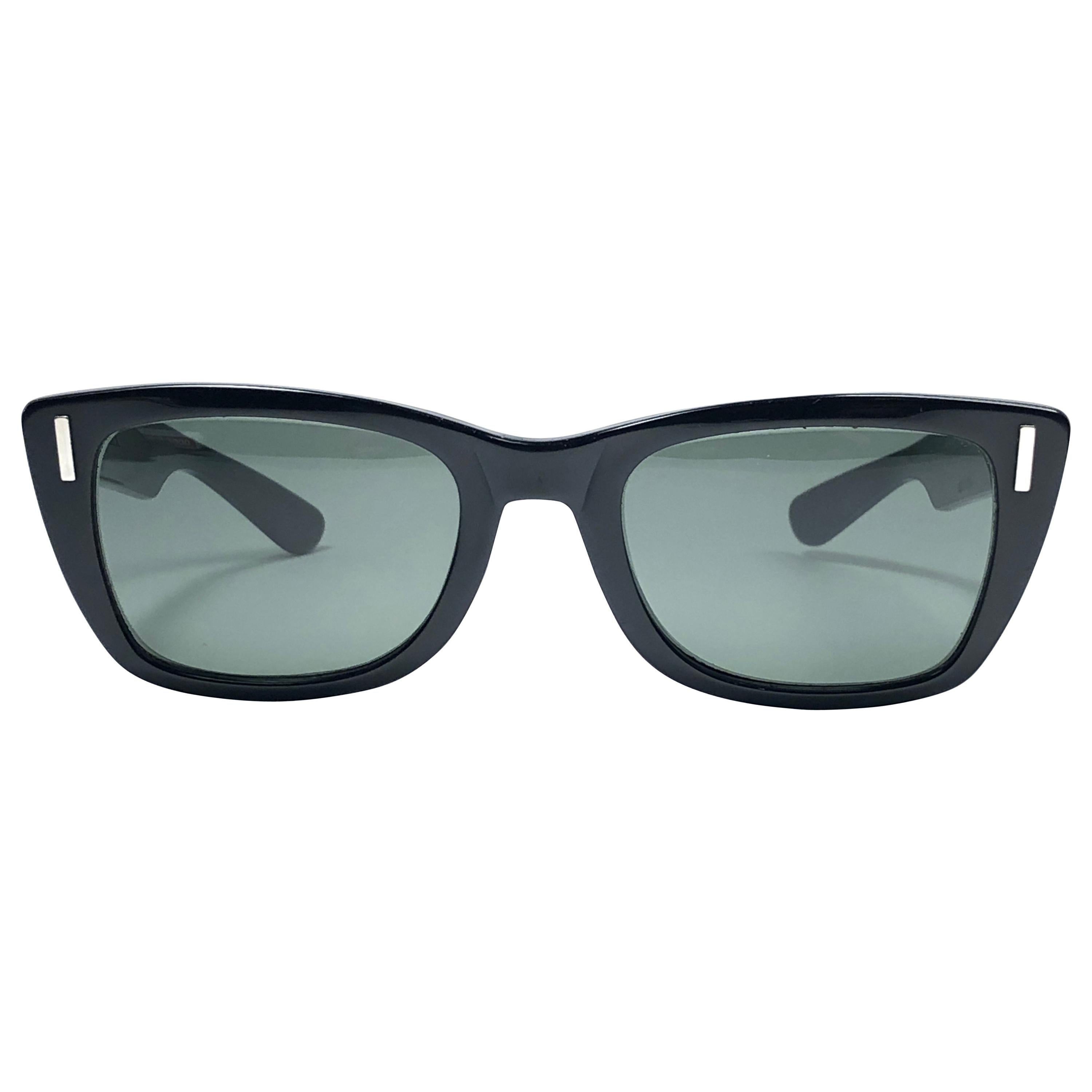 Super raro Ray Ban in stile Bob Dylan degli anni '60, in un elegante nero con accenti d'argento. Il grande artista indossò questo modello in diverse occasioni tra il 1960 e il 1965.
Bausch & Lomb Made in USA. Lenti grigie G15. Direttamente dagli
