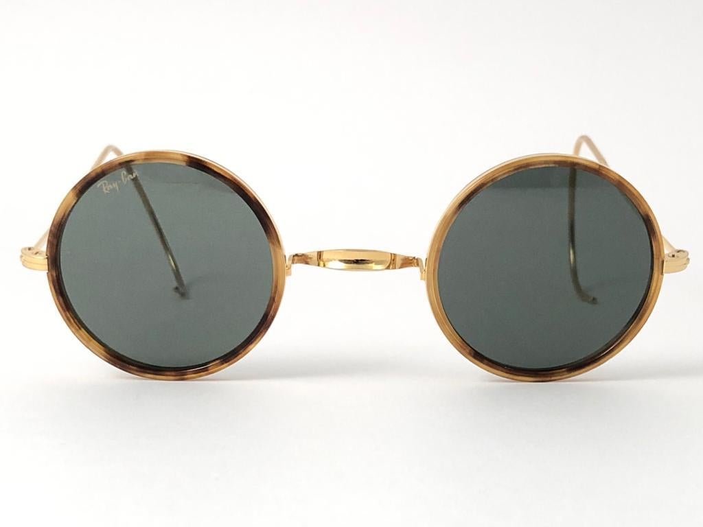 Nueva montura redonda vintage Ray Ban clásica Cheyenne con inserciones de tortuga y lentes grises G15.
Se entrega con su estuche original Ray Ban B&L con pequeños signos de desgaste debidos al almacenamiento.  
Este artículo tiene pequeños signos de
