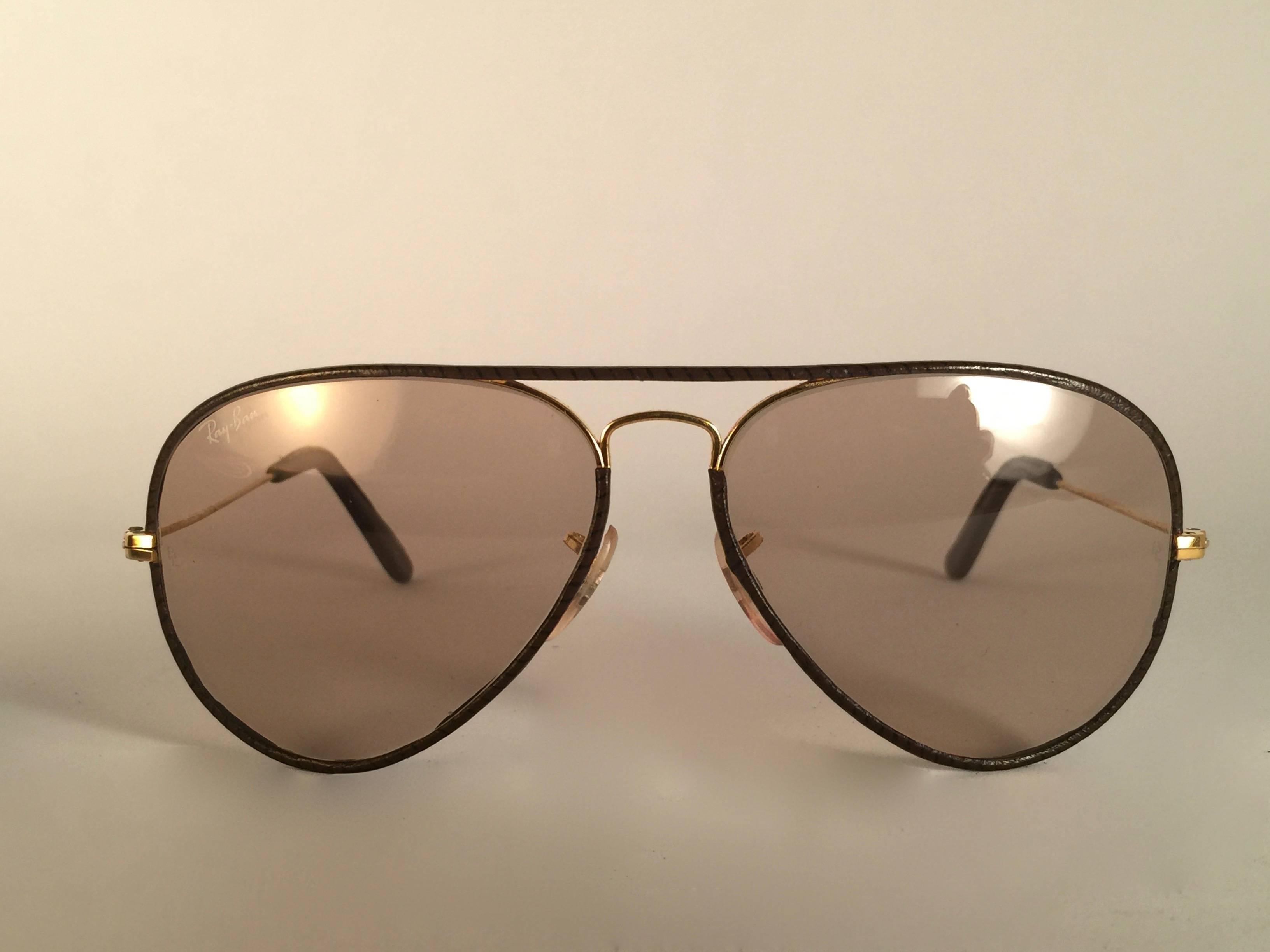 Vintage Ray Ban Leder Aviator 58Mm in tabakbraunem Leder mit goldenem Metall-Kombinationsrahmen Sporting Light Changeable zu braunen Gläsern mit weißem Ray Ban Logo. B&L geätzt in den Linsen, so Mitte der 1970er Jahre. Kommt mit seinem Original Ray