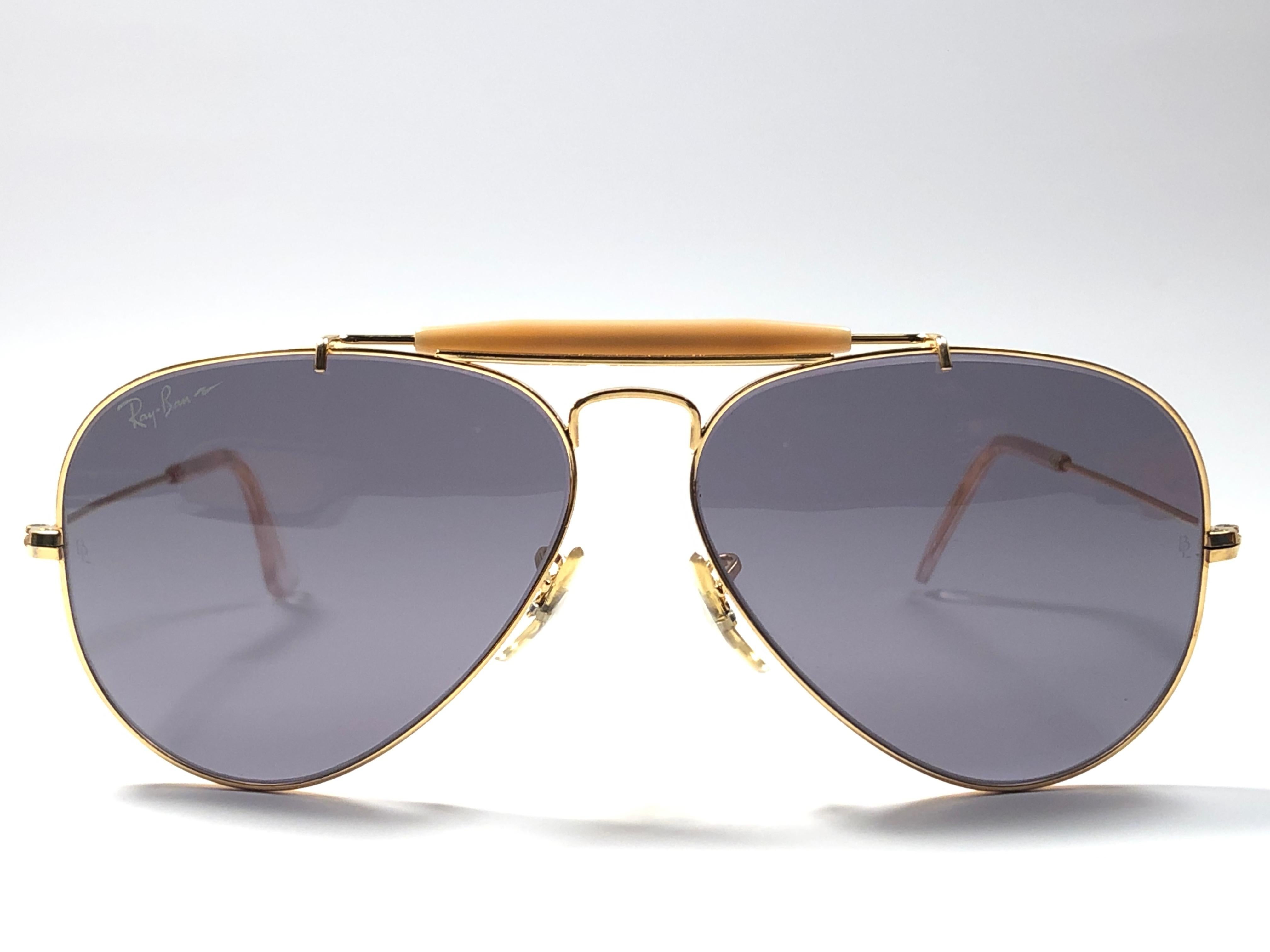 Vintage Ray Ban Outdoorsman gold 58MM frame with G20 Grey lenses.
This item is preowned, therefore have light scratches on the lenses, the frame is in near perfect condition with no repairs or structural damages. Original Ray Ban B&L case.