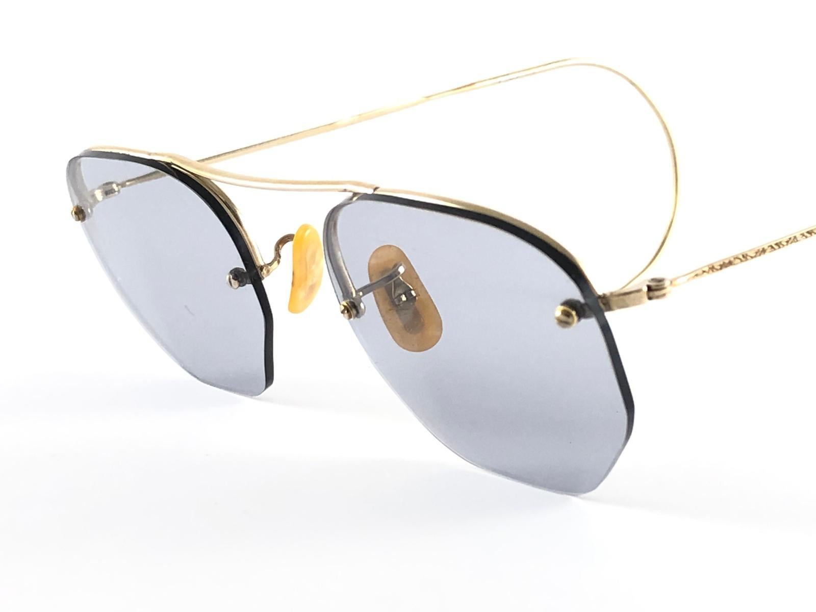 Ray Ban B&L Randlos vergoldet mit mittelgrauen Linsen.  12 Karat Gold gefüllt Rahmen.
Bitte beachten Sie, dass dieser Artikel fast 50 Jahre alt ist und aufgrund der Aufbewahrung leichte Abnutzungserscheinungen aufweist. Filigrane Bügel. 
Das seltene