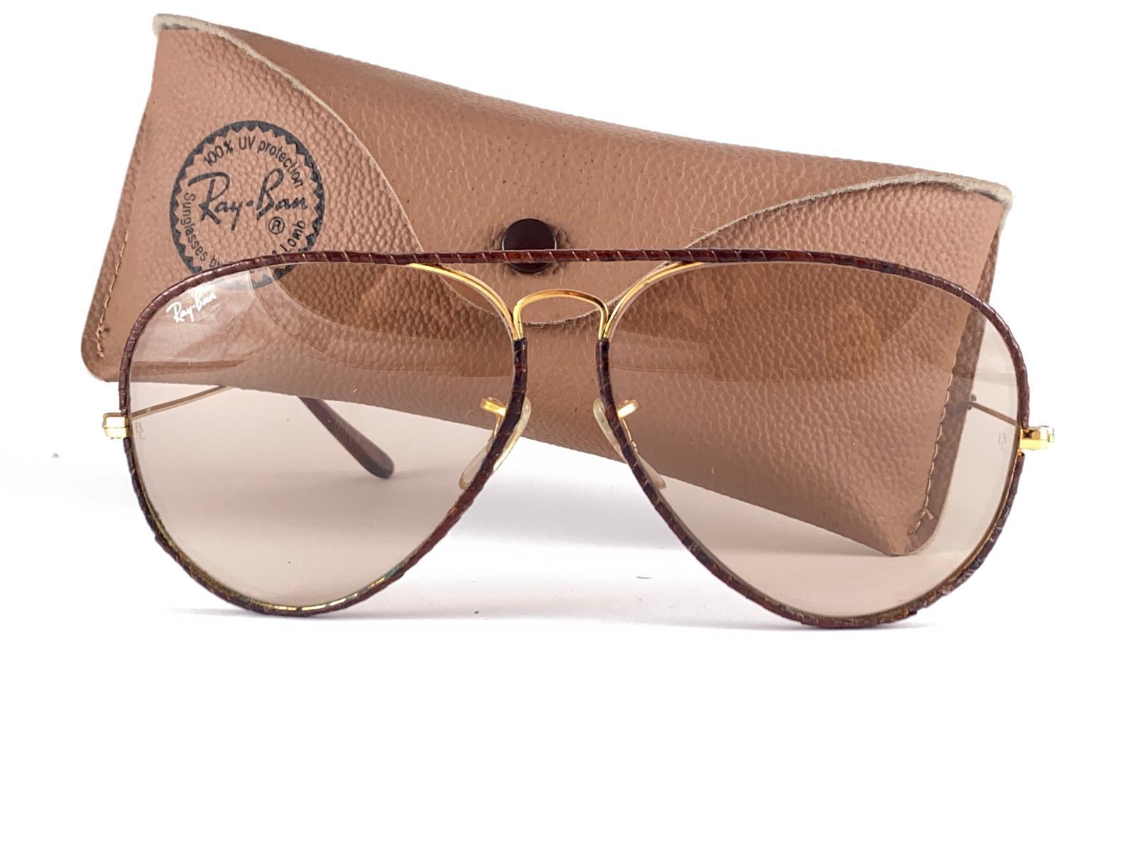  Vintage Ray Ban Leathers 62mm in brown leather with gold metal combination frame. 

Mint Brown Changeable Lenses.
Comes with its original Ray Ban B&L case with minor sign of wear due to storage. 
The Leather Has Small Wear. Please Study The