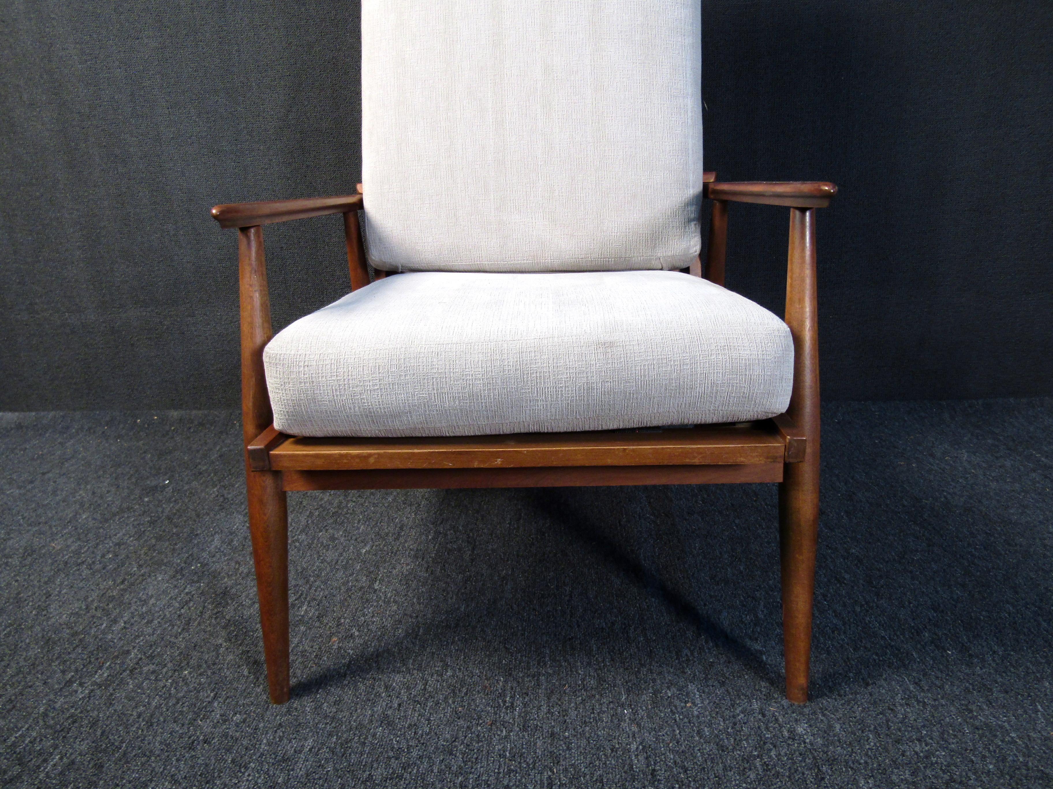 This vintage armchair combines Mid-Century Modern style with quality materials and comfortable design. Upholstered cushions, a reclining back and a sleek walnut frame make this chair a unique choice for any reading corner or sitting room. Please