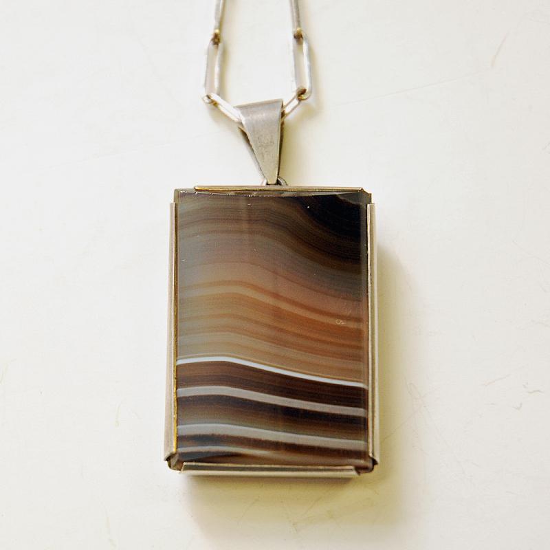 A wonderful naturstone silver necklace with lovely patina from the 1970s Sweden. Natural brown agate stone in faboulous earth colors surrounded by a solid silver frame. The locker can attach to any chain link, in which makes it easy to adjust the