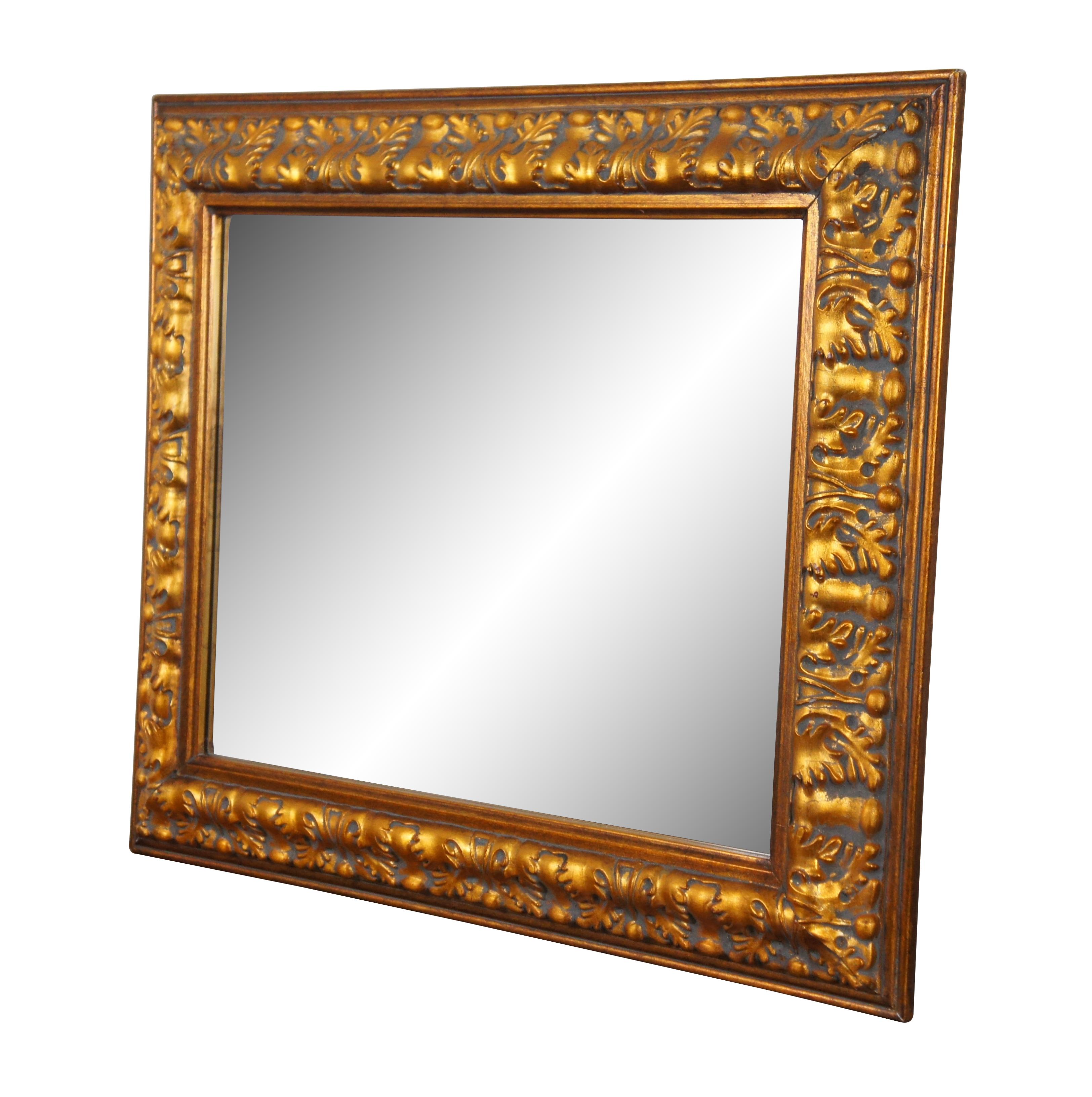Late 20th century beveled rectangular wall mirror featuring a bold design of oak leaves and acorns. Molded plaster / composite frame finished in a deep, metallic gold. Can be hung vertically or horizontally. Manufactured by JJ International,