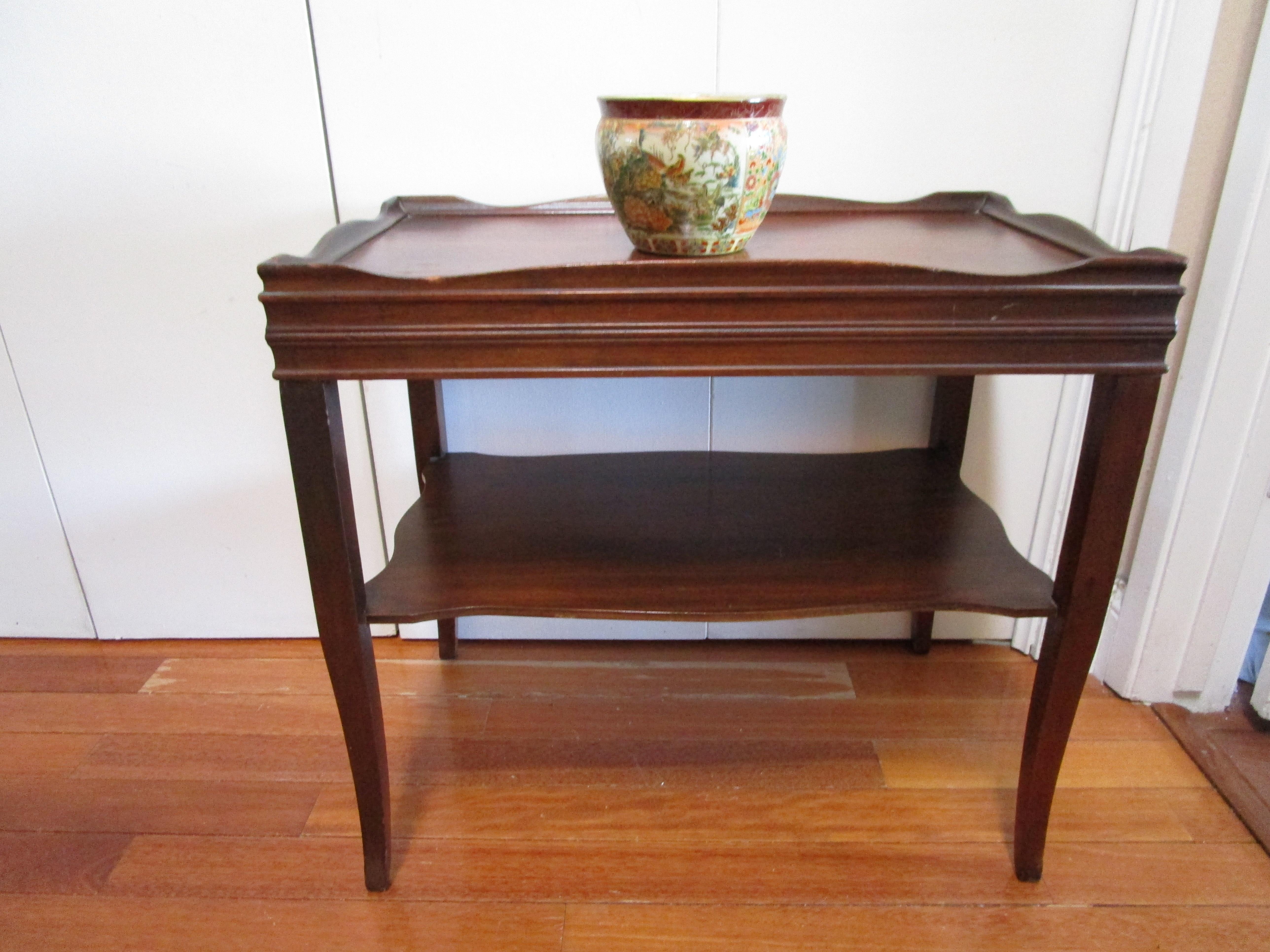 Il s'agit d'une table basse ou table à thé rectangulaire en acajou vintage que nous adorons.  Il est robuste et attrayant, avec des touches de style français, mais fabriqué aux États-Unis. 
Cette table est apparue lors d'une vente aux enchères de
