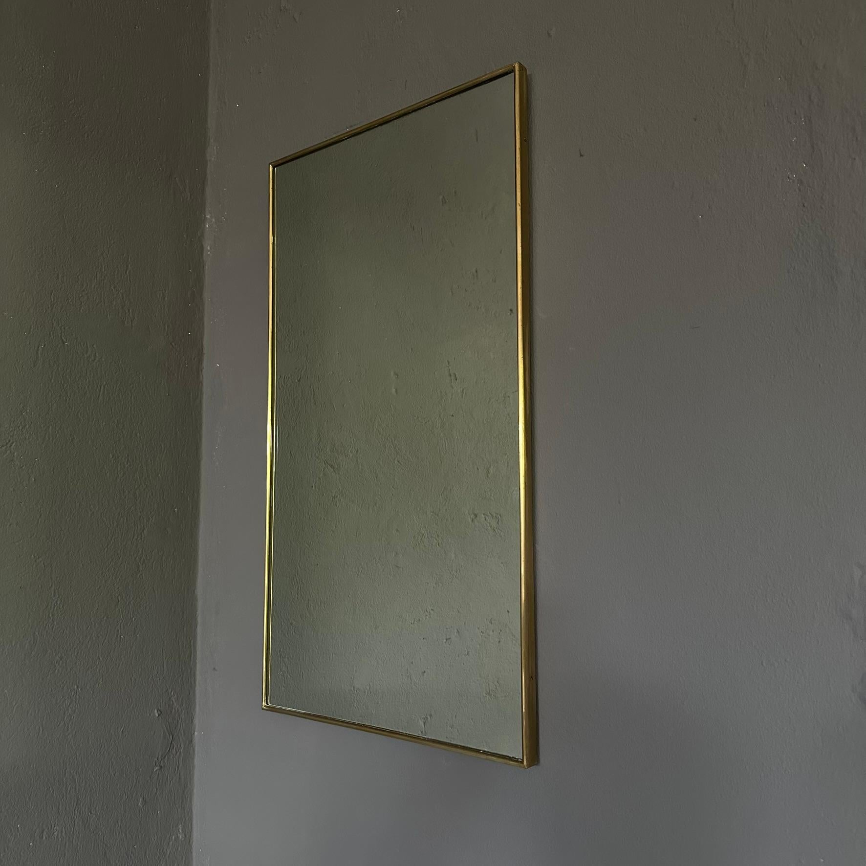 Miroir rectangulaire vintage des années 1950 avec un cadre en laiton.
Le miroir, fabriqué en Italie, est doté d'un cadre en laiton sur tout son périmètre.