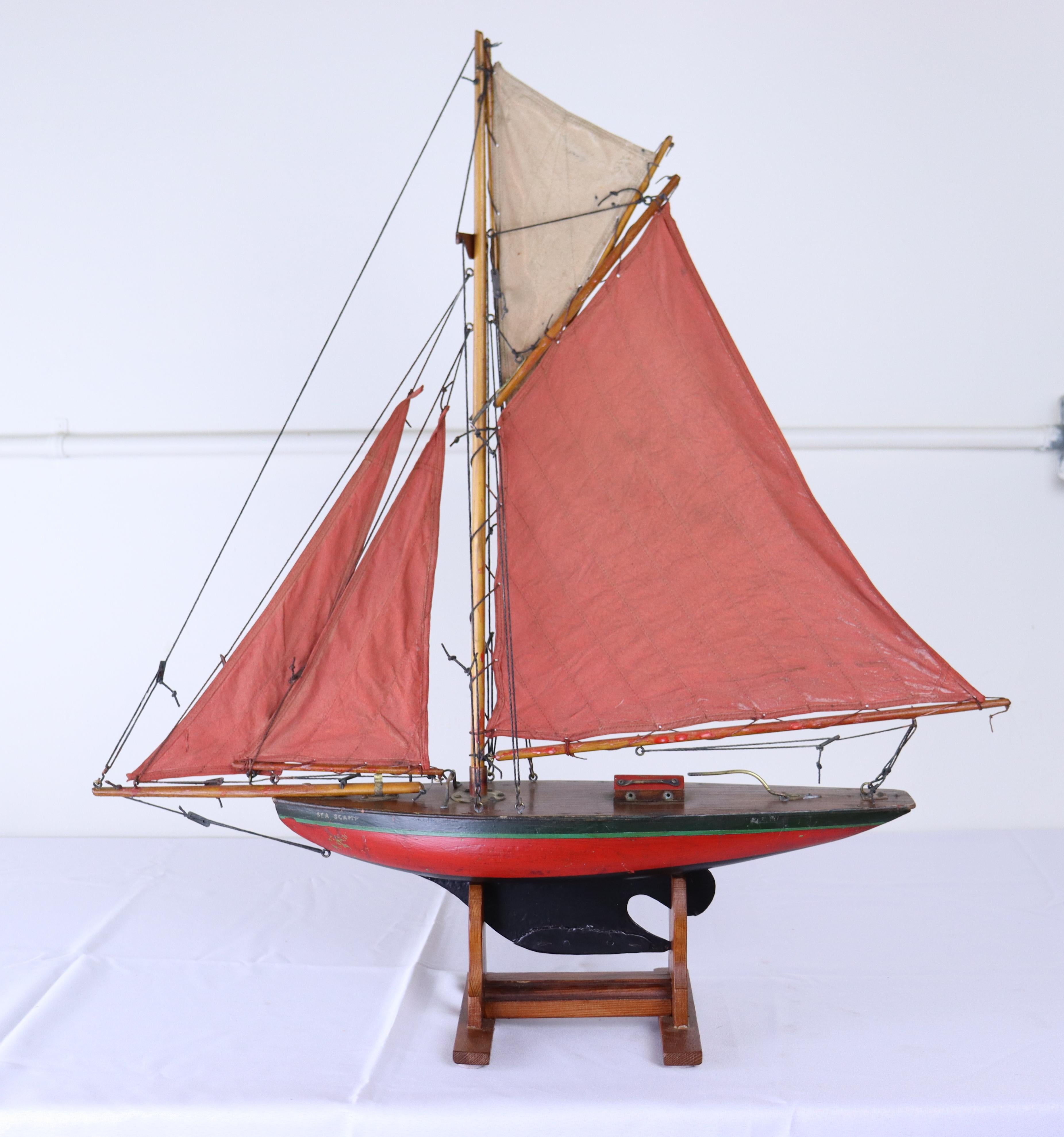 Une charmante maquette de yacht vintage avec des voiles fabriquées à partir d'anciennes toiles à voile et des accents en laiton d'origine.  Baptisé 