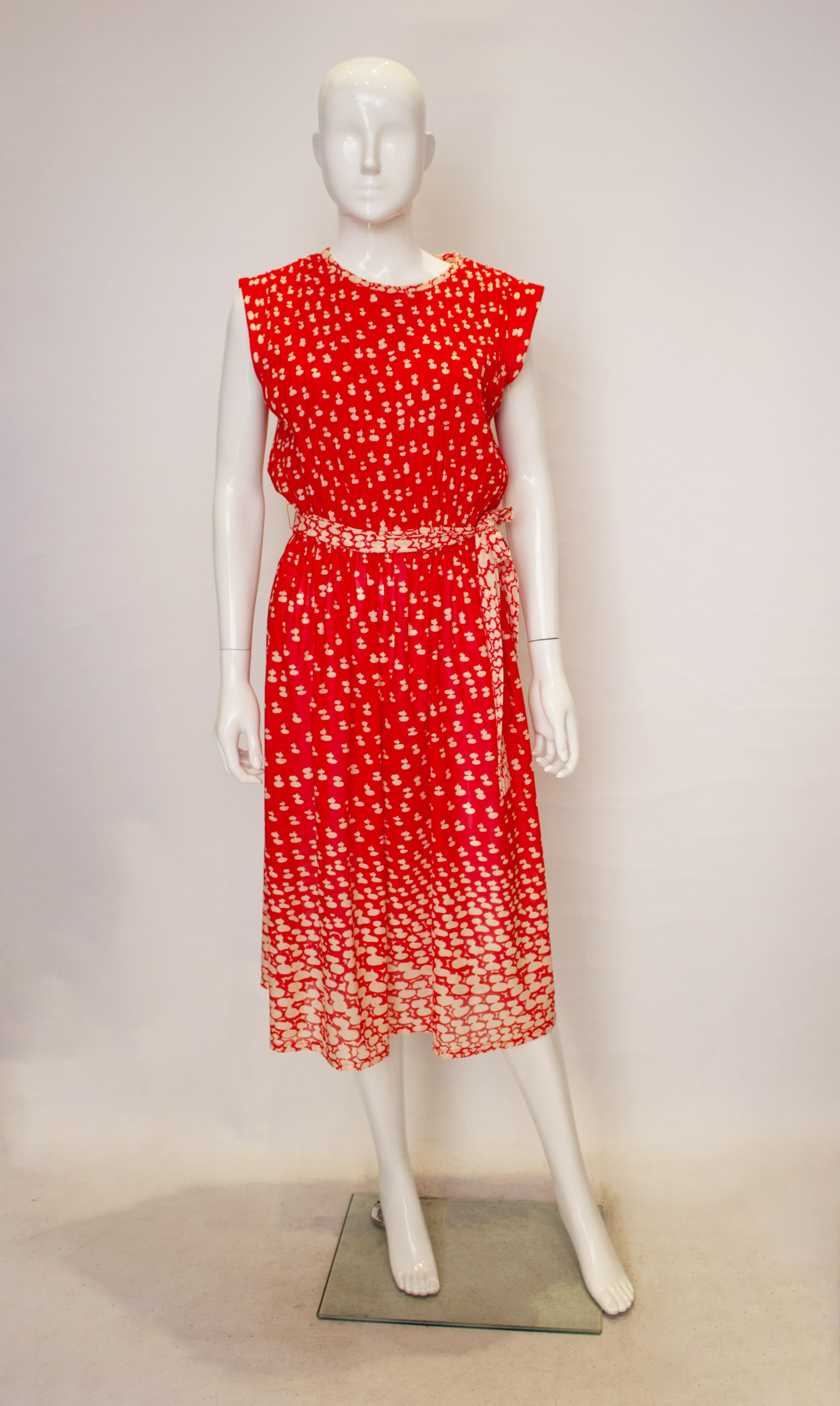 A chic vintage cocktail dress in wonderful combination of print and pleats. The dress has a keyhole opening at the back , pattern detail at the hem and a self fabric belt. The dress has an elasticated waist and will fit a waist 26'' - 29''